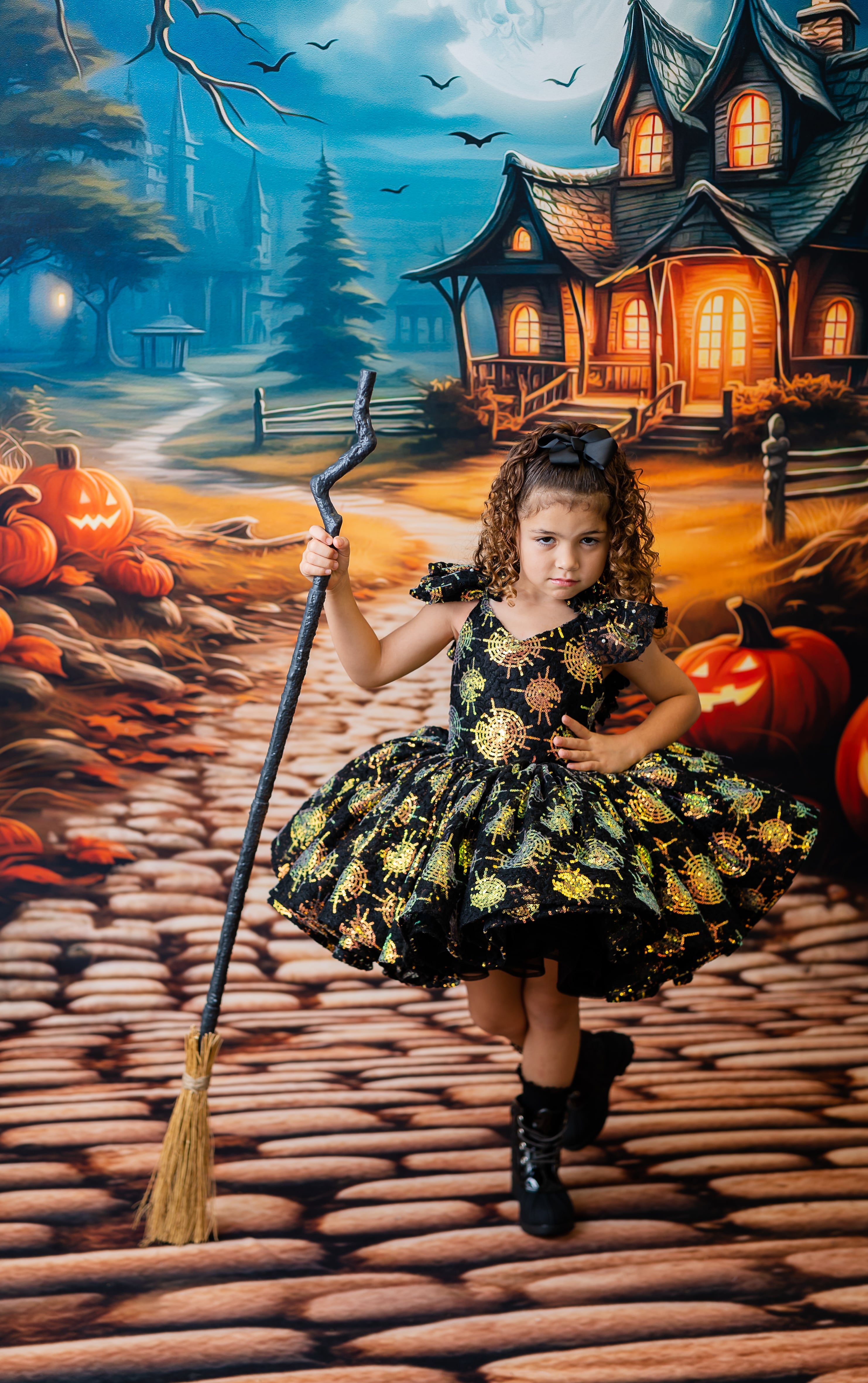 little girl wearing a spider themed dress for halloween