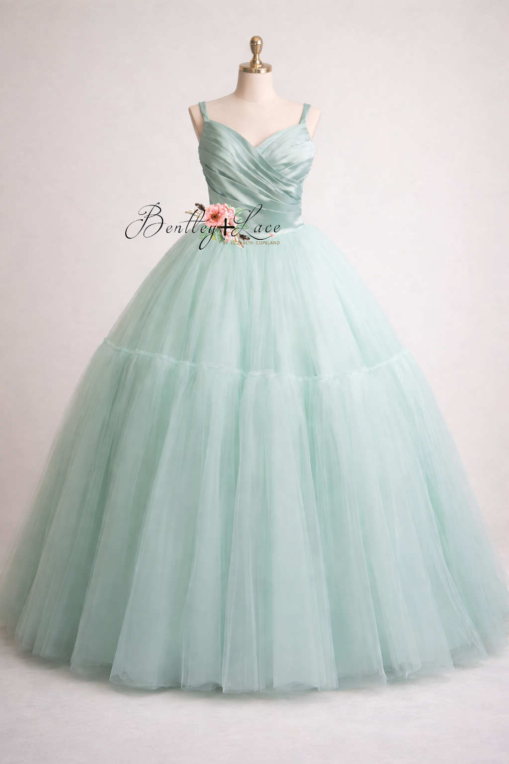 Mint green evening gown on a mannequin with a white background