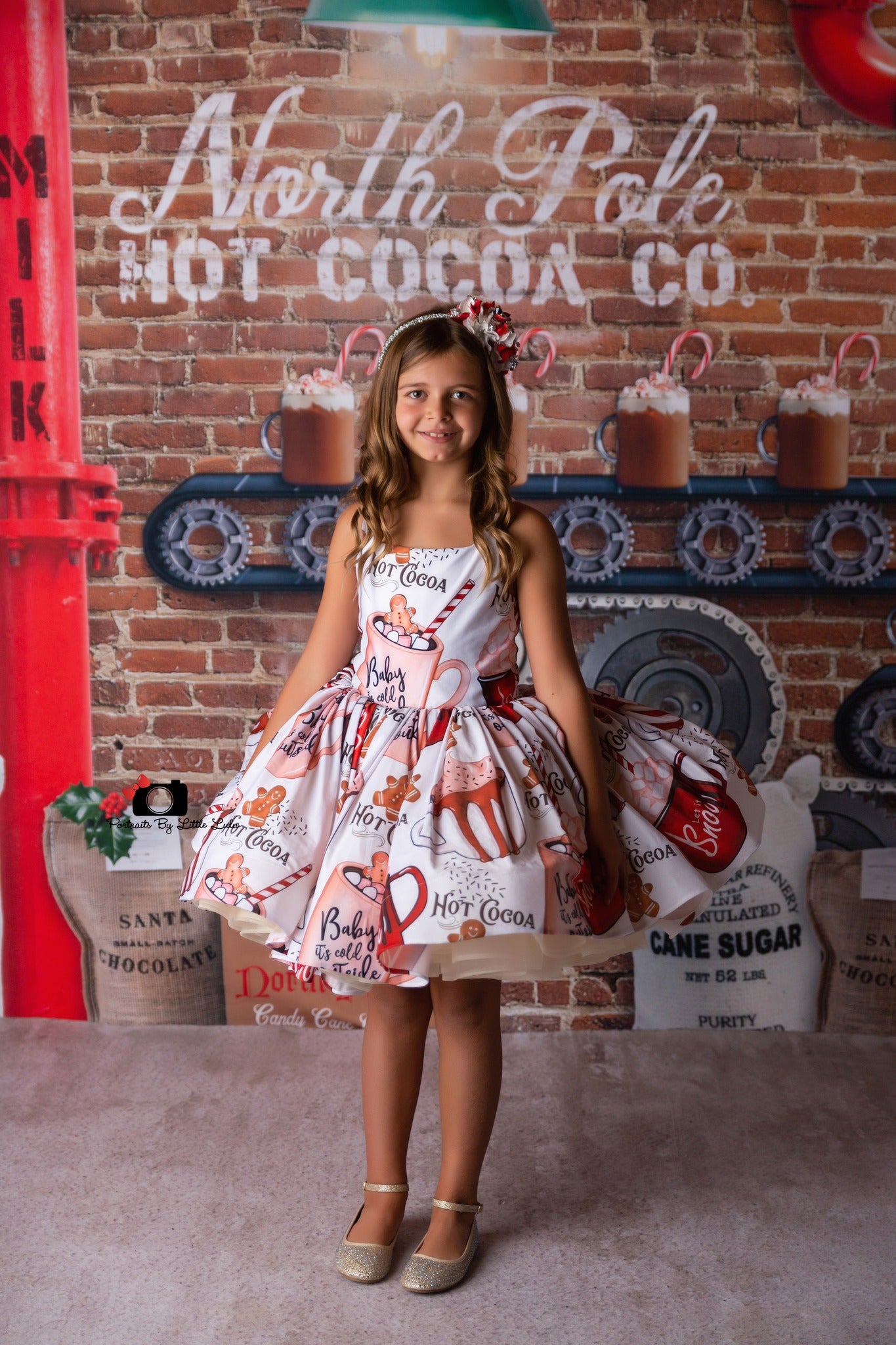 Child in ballerina-style holiday dress holding a mug of hot chocolate