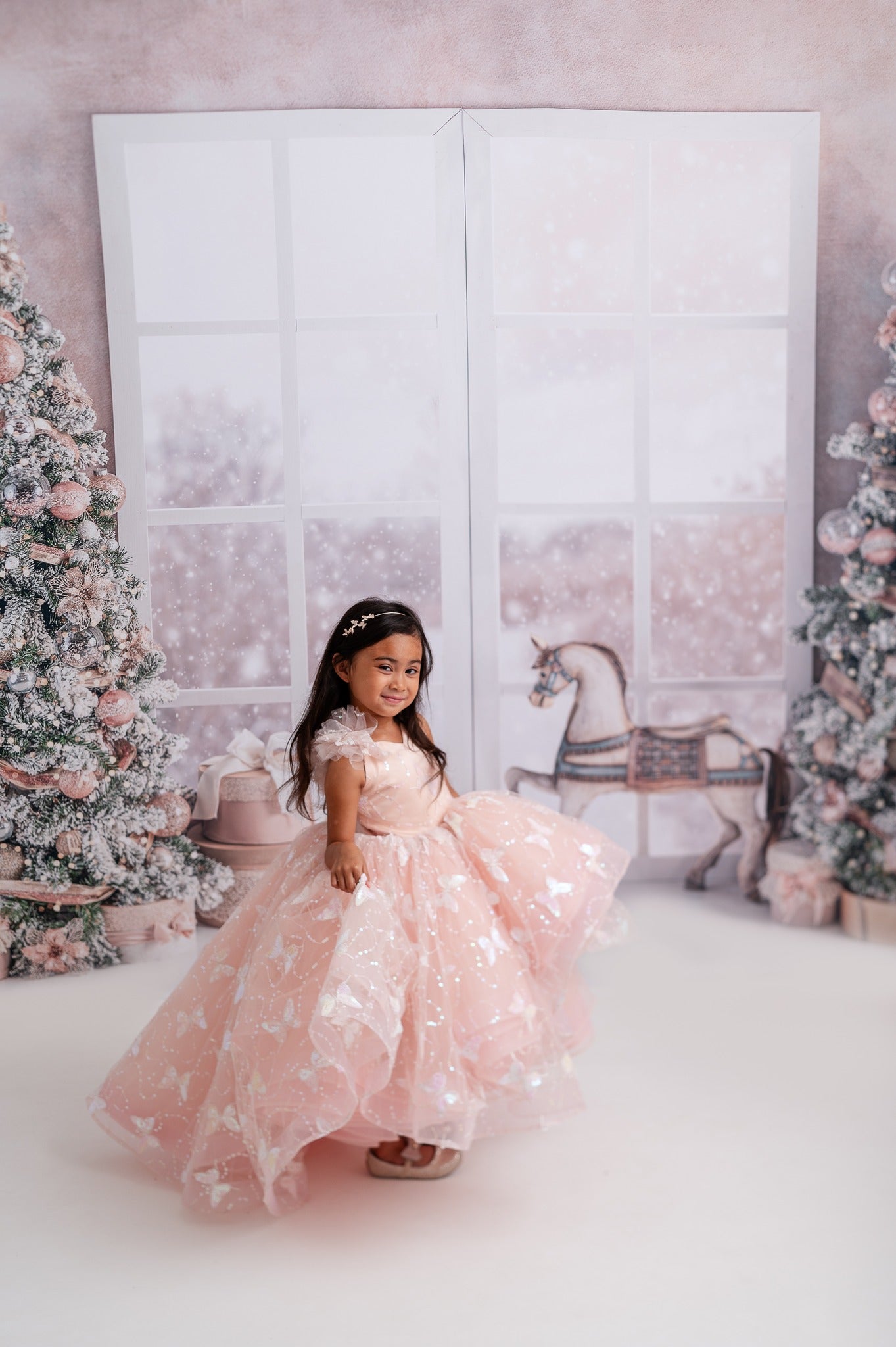 "A child wearing the Anastasia gown during a photoshoot, capturing the elegance and playful charm of this special occasion dress."
