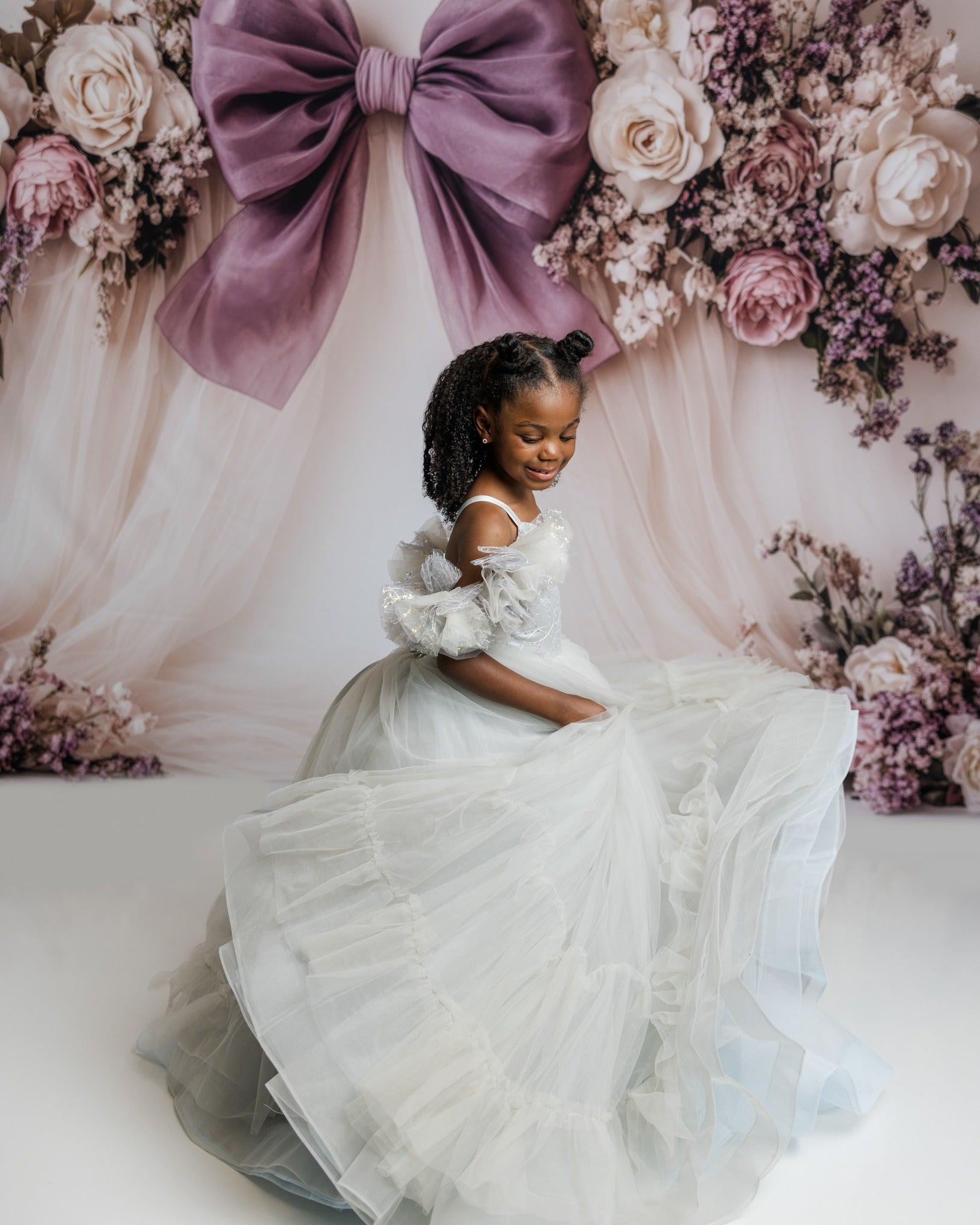 Young girl twirling in a dreamy couture gown during a styled photo session