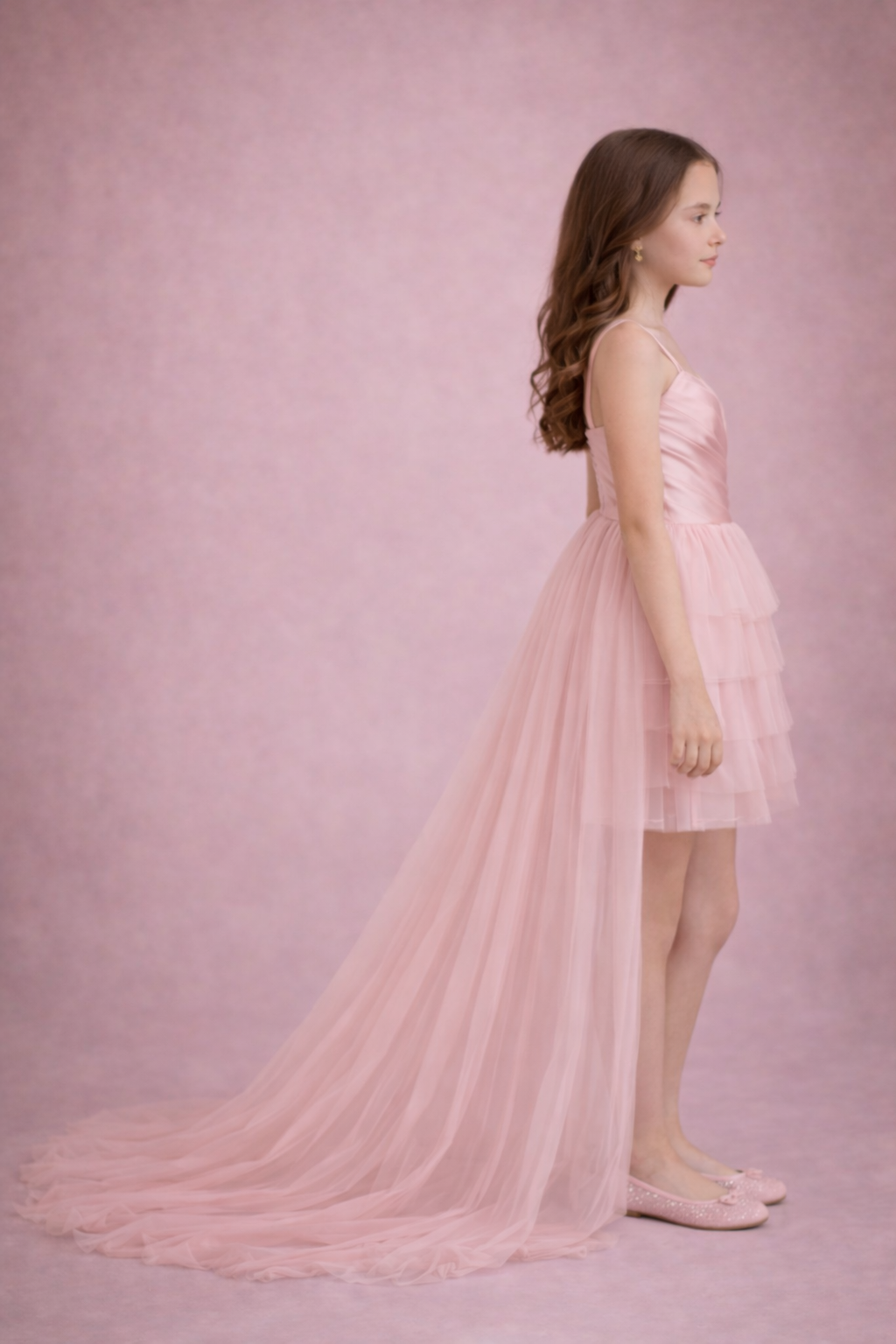 Young girl wearing a pink dress against a pink background