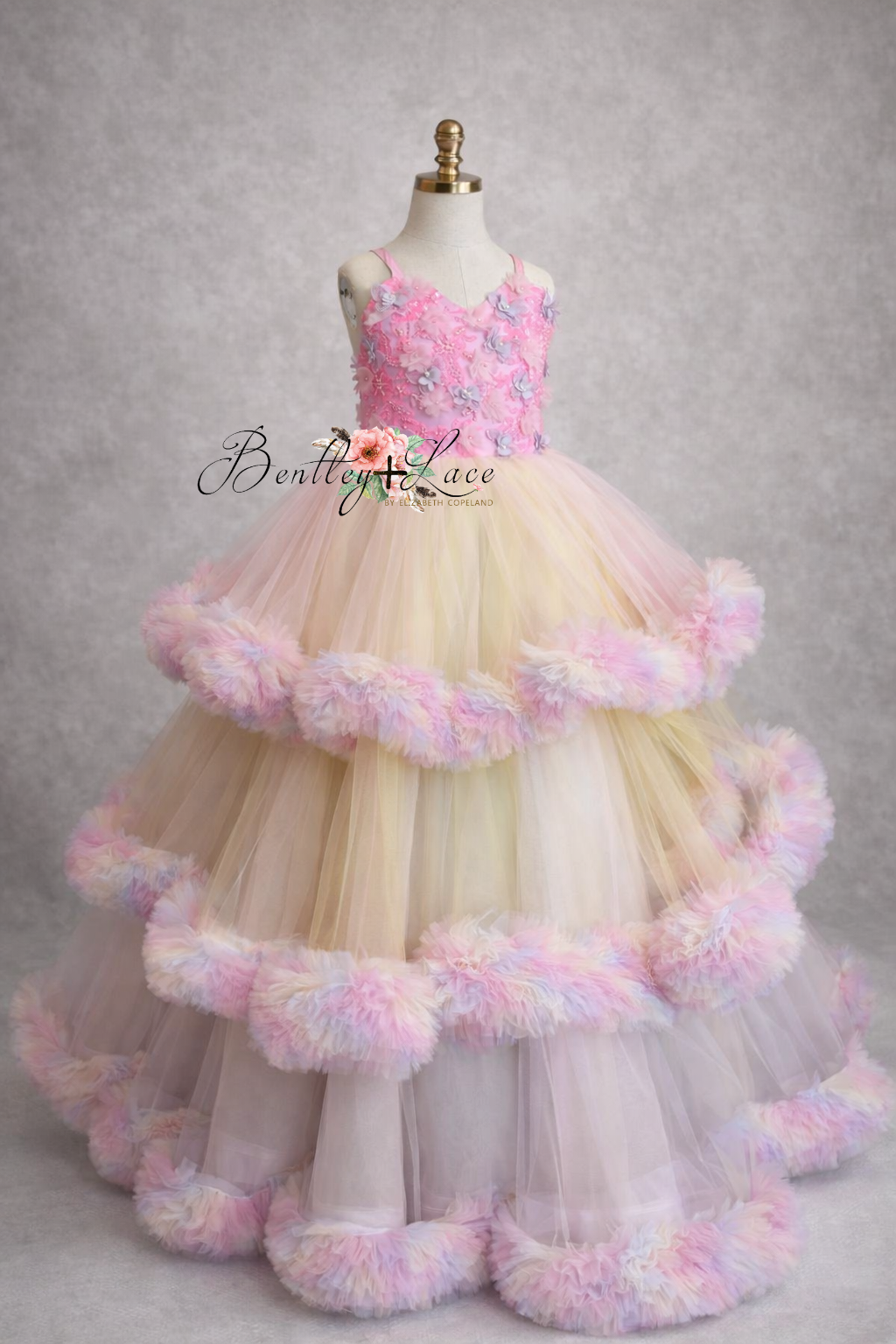 Pink and white floral dress on a mannequin against a gray background