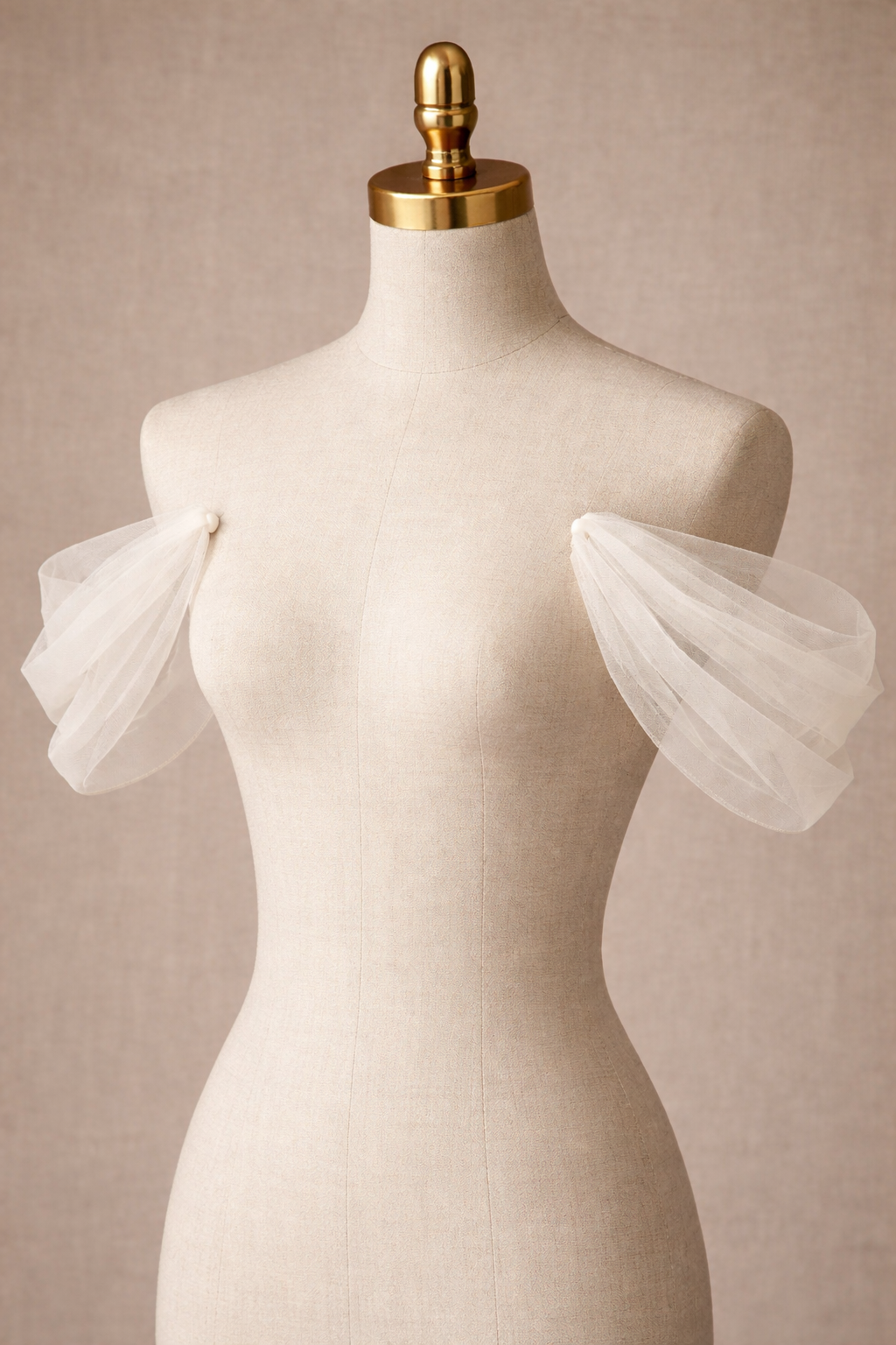 Mannequin wearing a white dress with sheer sleeves against a beige background