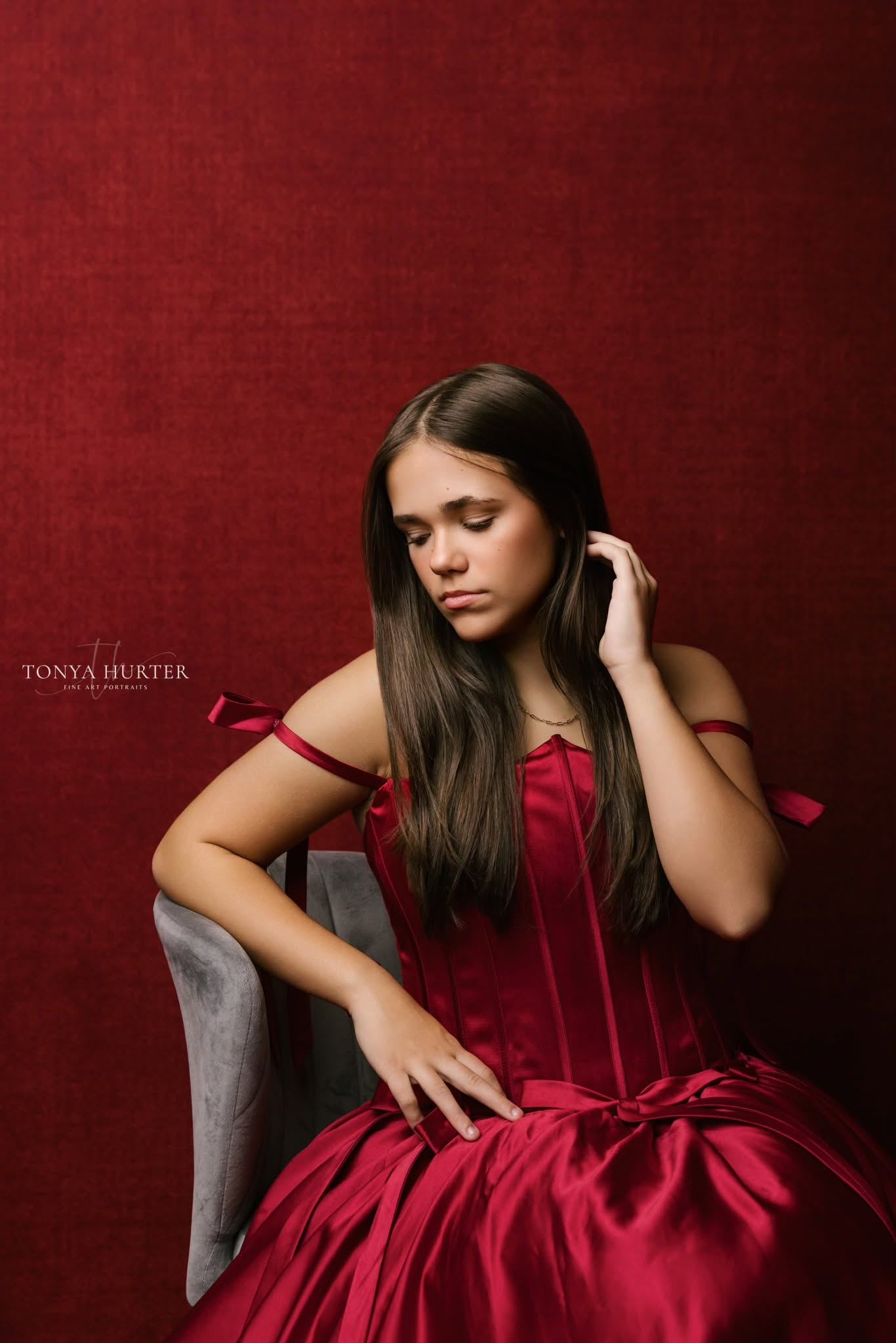 Dramatic red satin portrait gown with structured corset bodice