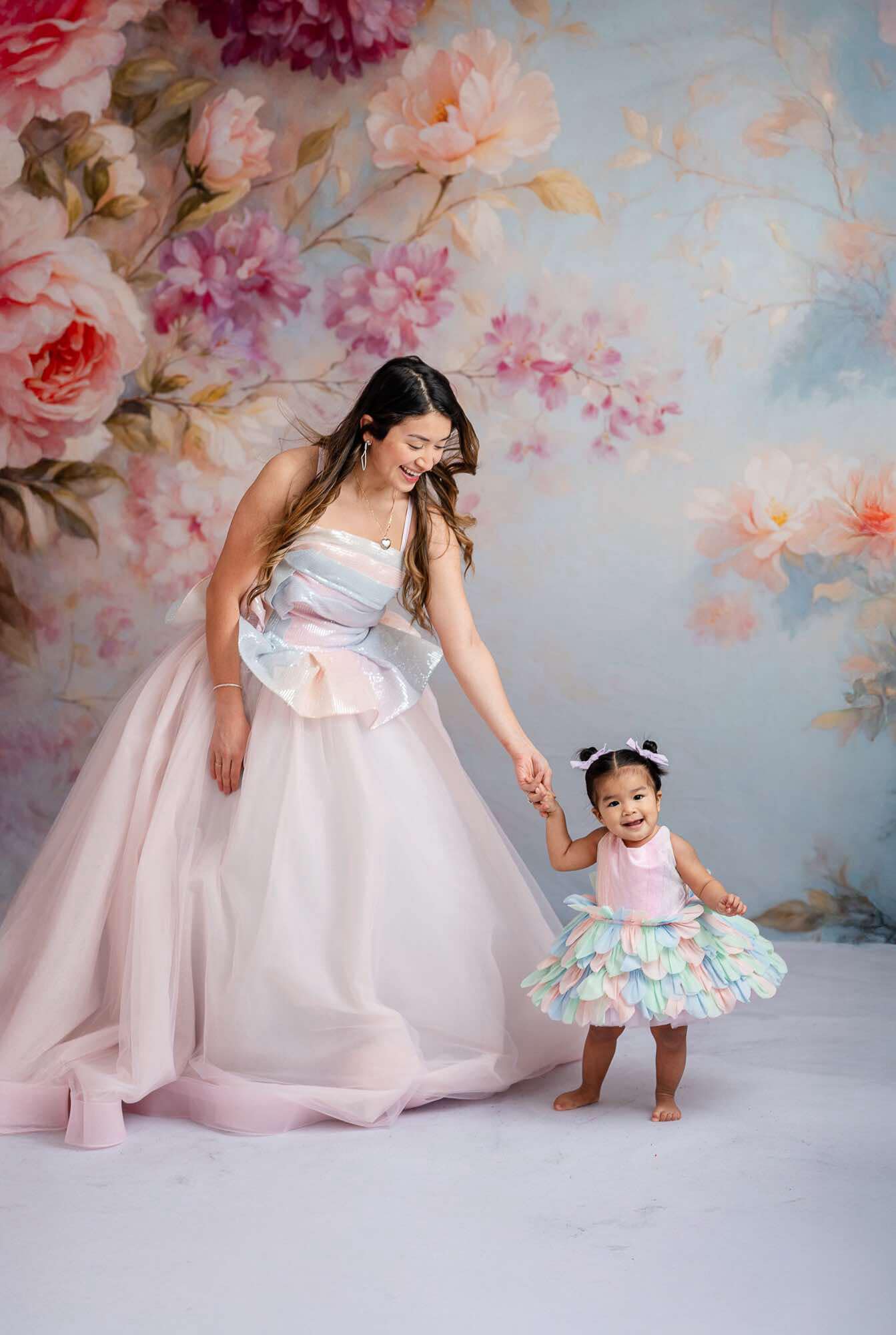 "Fairy-tale inspired gown featuring soft pastel hues and petal layers."