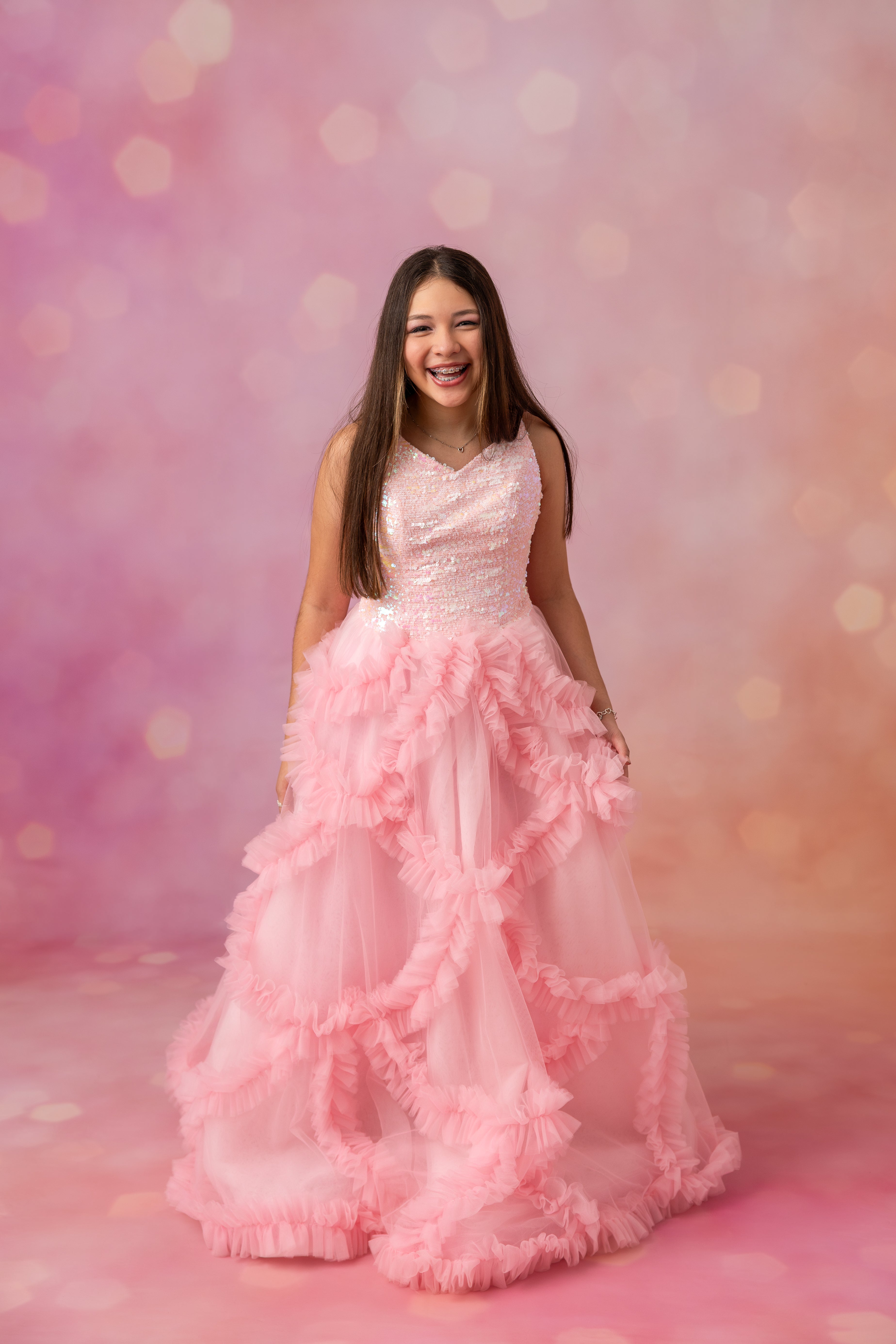 Young girl in a pink dress against a soft pink background