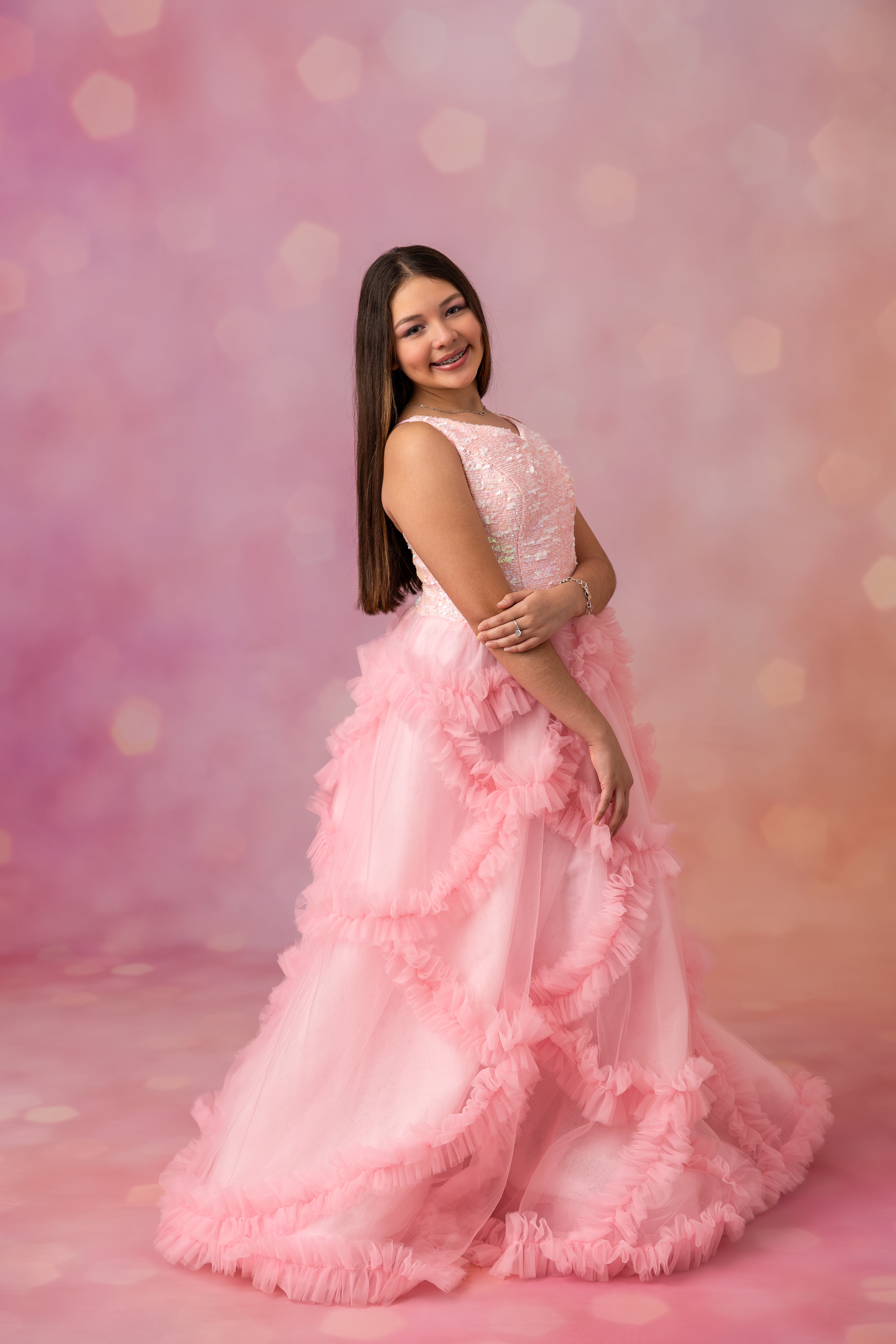 Woman in a pink floral dress against a soft pink background