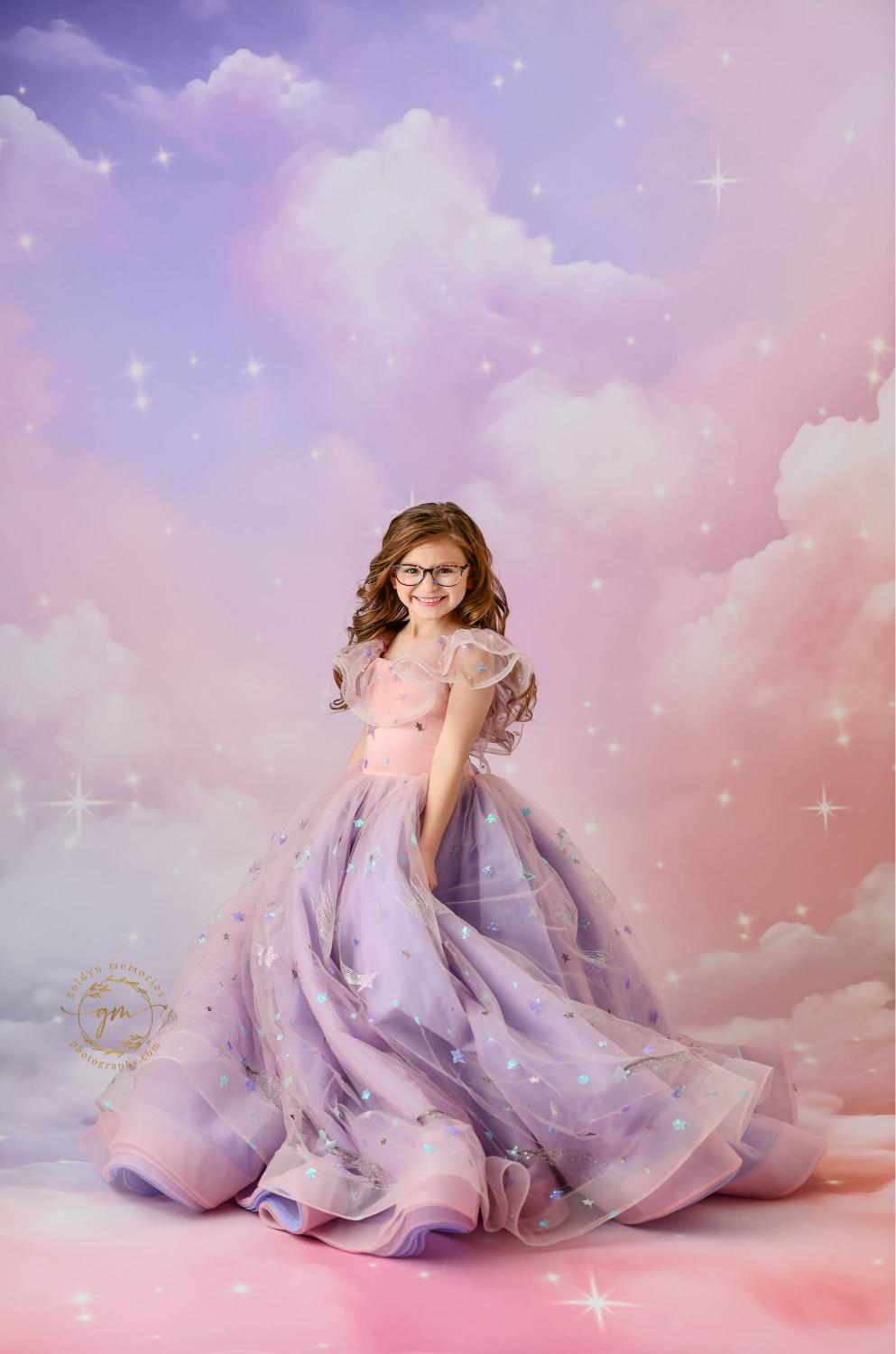 "A young girl in a whimsical pink and purple gown with star embellishments, set against a dreamy pastel sky backdrop with sparkling stars."