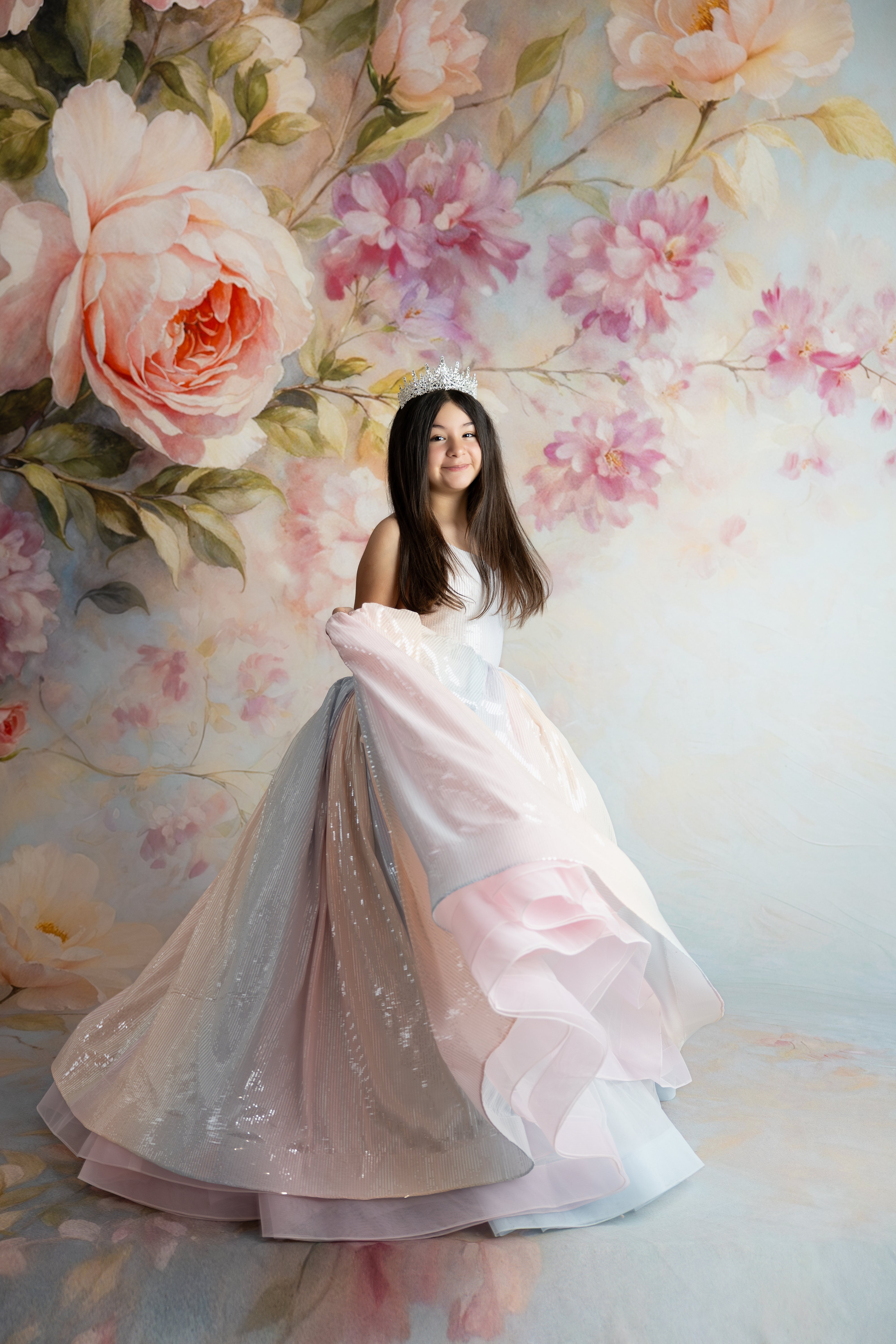 Young girl twirling in the pastel ombré Aurora Gleam Gown with flowing tulle sleeves