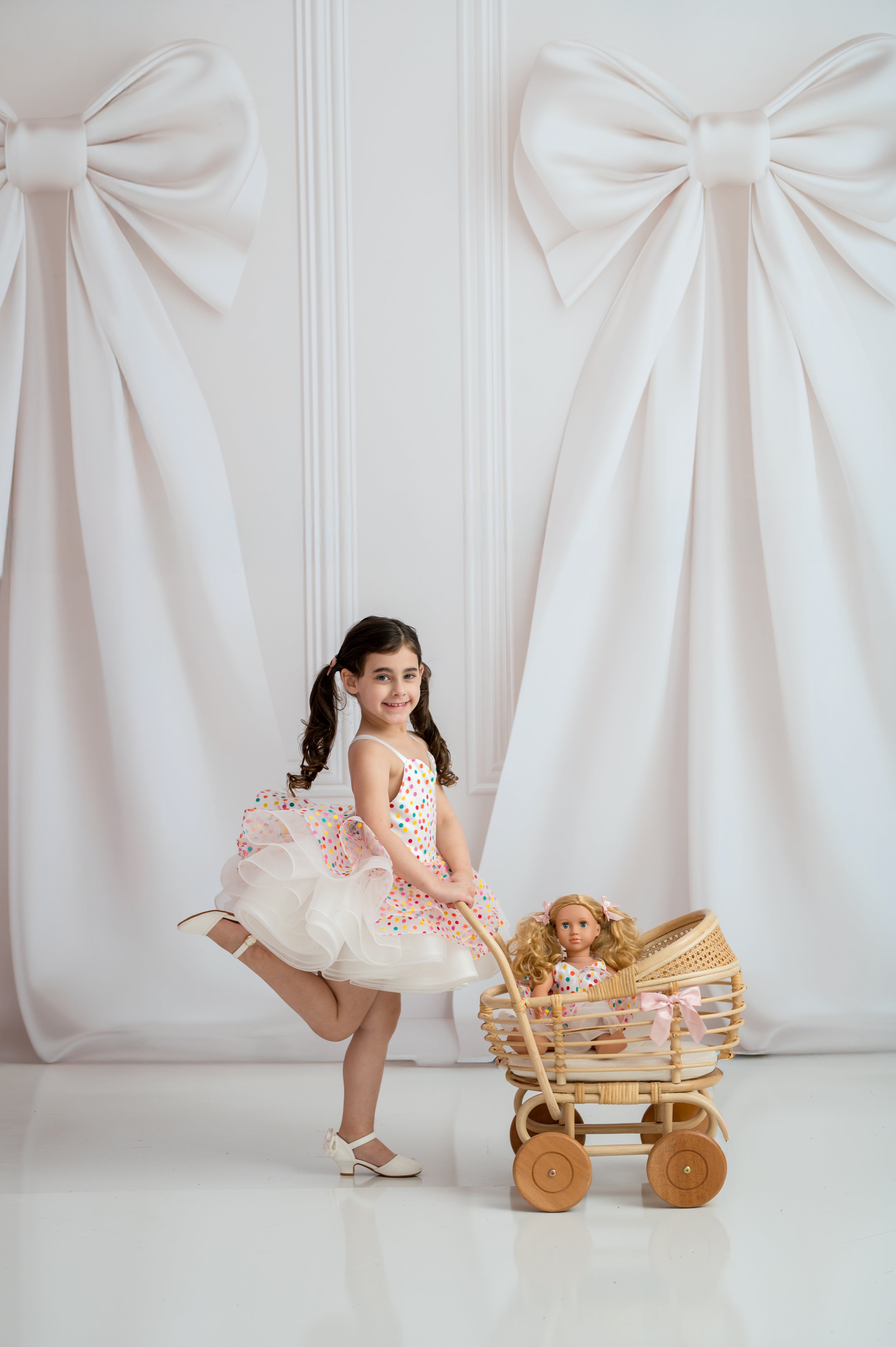 Boutique girls dress on mannequin with gold stand and soft white draped background