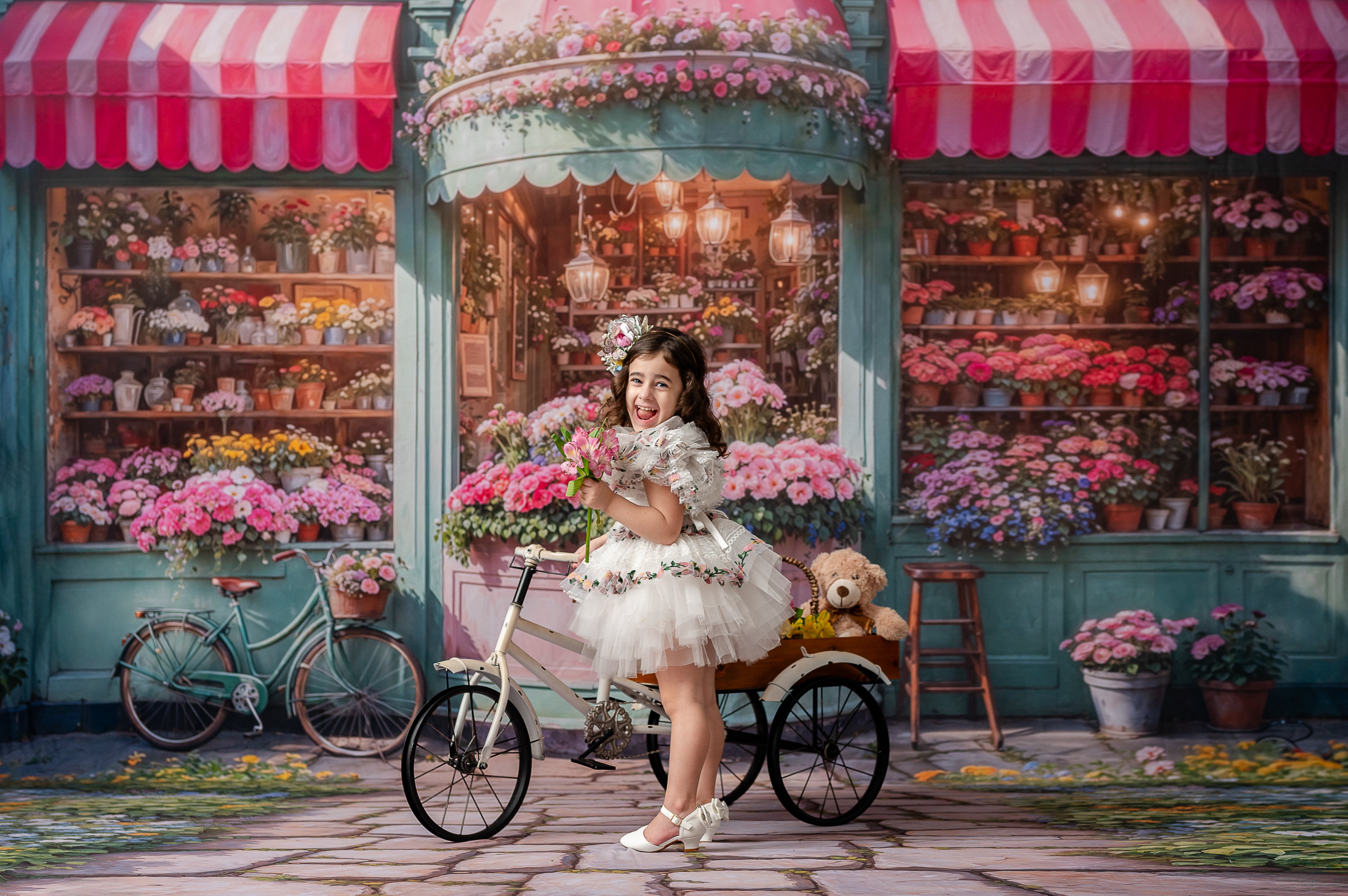"A little girl dressed in an elegant floral-trimmed dress beams joyfully in front of a vintage-style flower shop setting."