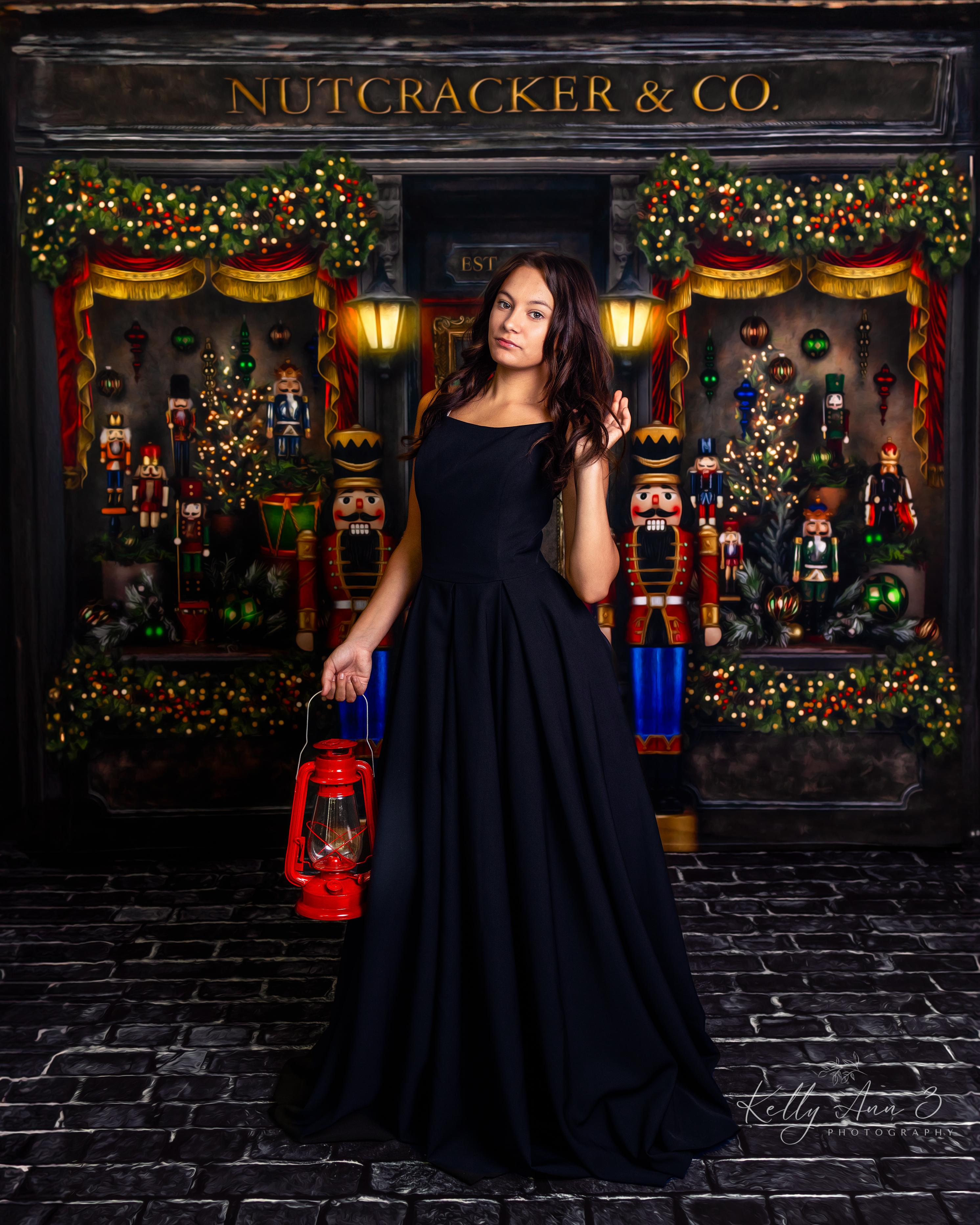Woman in a black dress holding a red lantern in front of a Nutcracker & Co. store display.