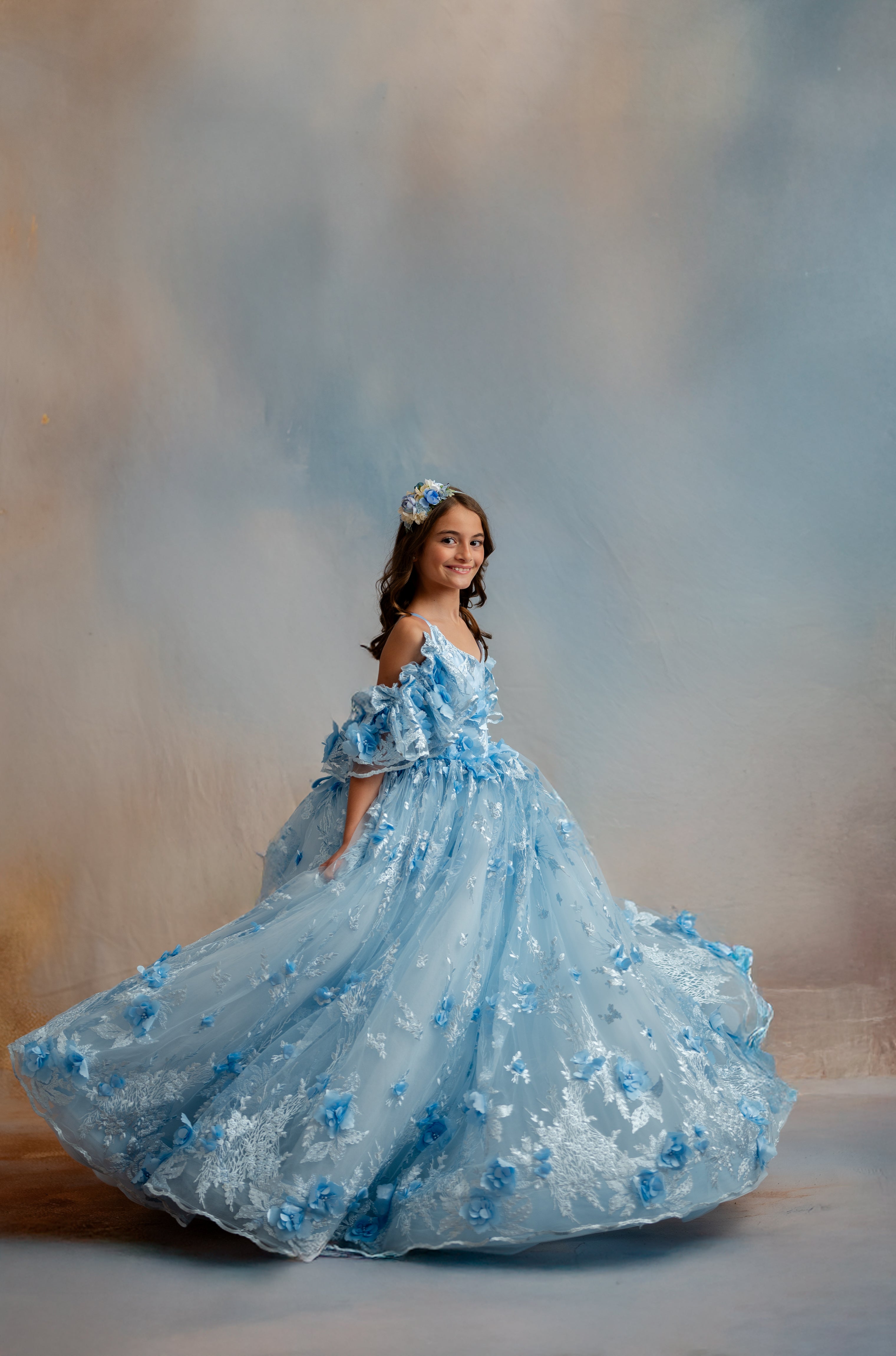 Woman in a blue floral dress against a blurred background
