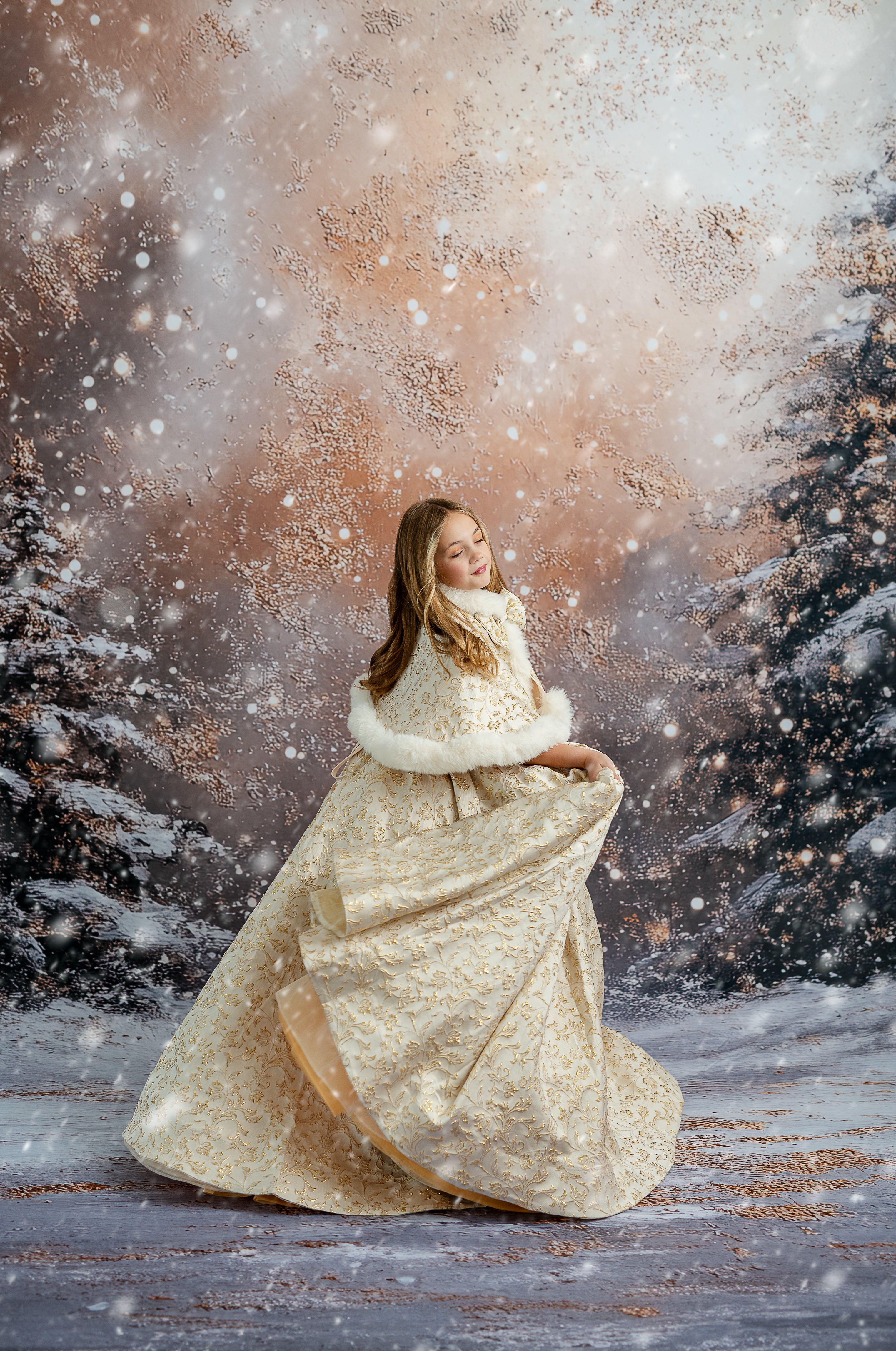 Woman in a white dress standing in a snowy forest with snow falling.