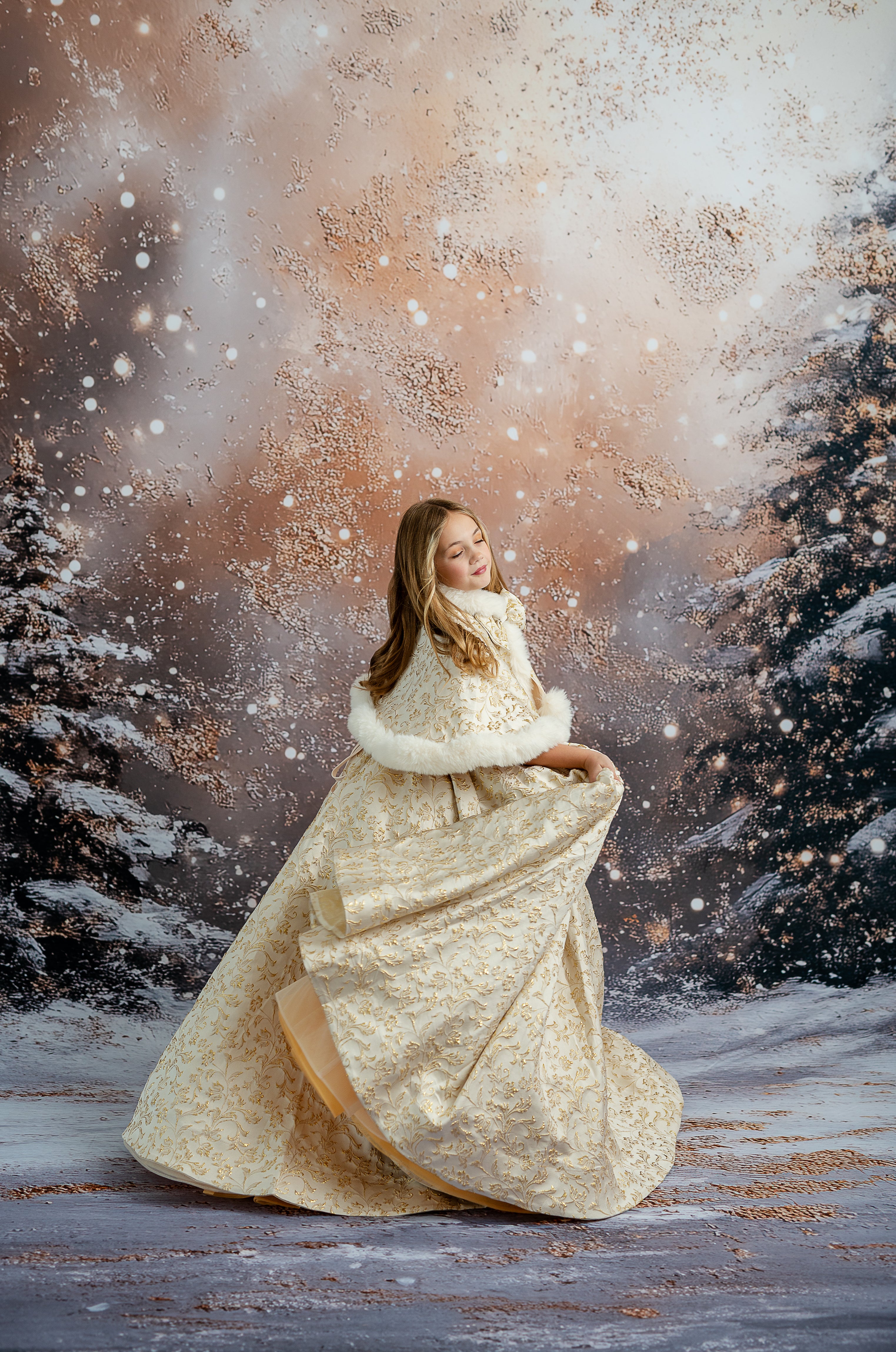 Woman in a long, light-colored dress with a fur stole standing in a snowy forest.