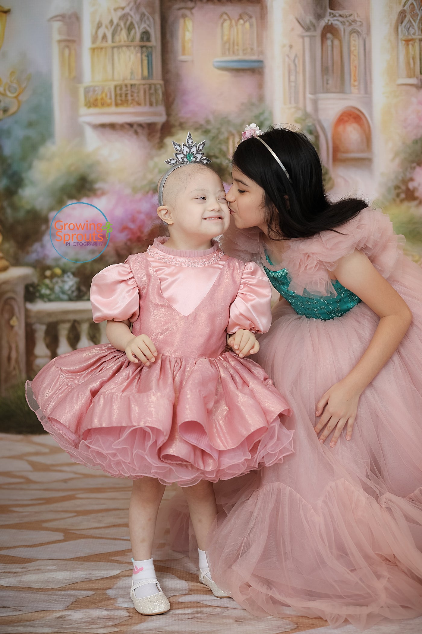 A smiling family posing together during a Leia's Kids event sponsored by Bentley + Lace, surrounded by balloons and decorations.