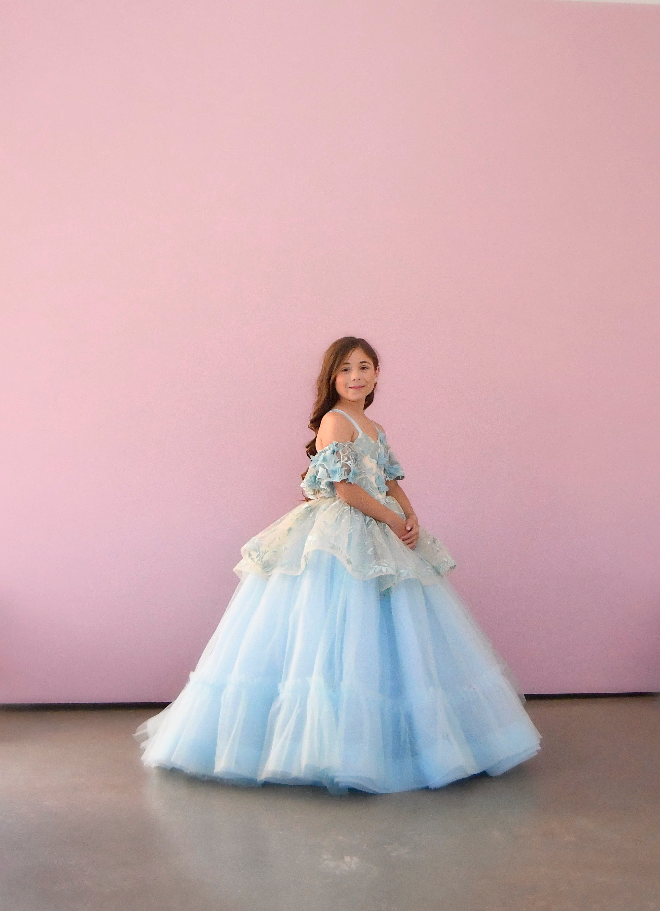 "Side view of the Trésor Caché gown featuring the peplum skirt detail, adding volume and a playful twist to its classic design."