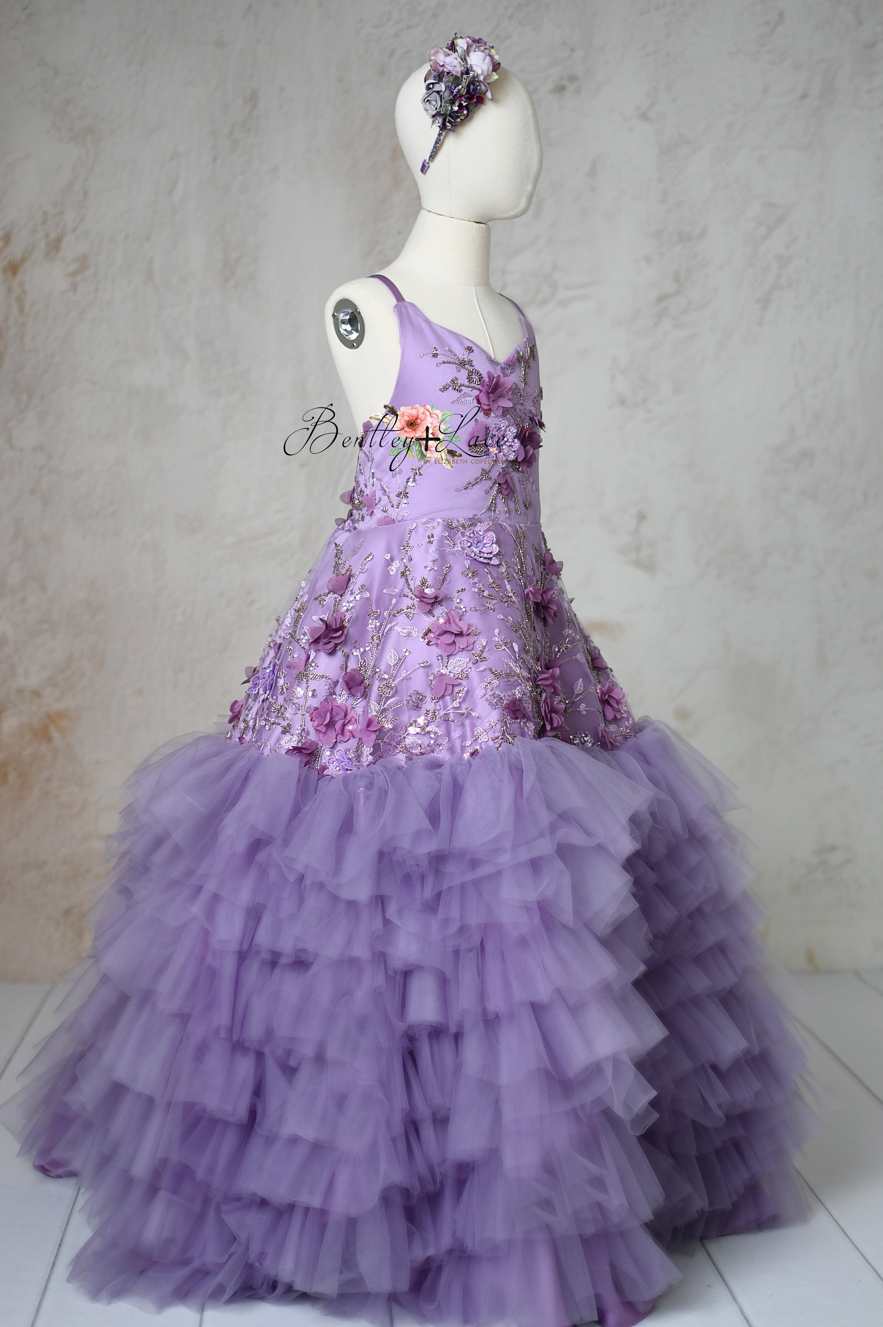 Lavender floor-length gown with floral appliqués and detachable puff sleeves.