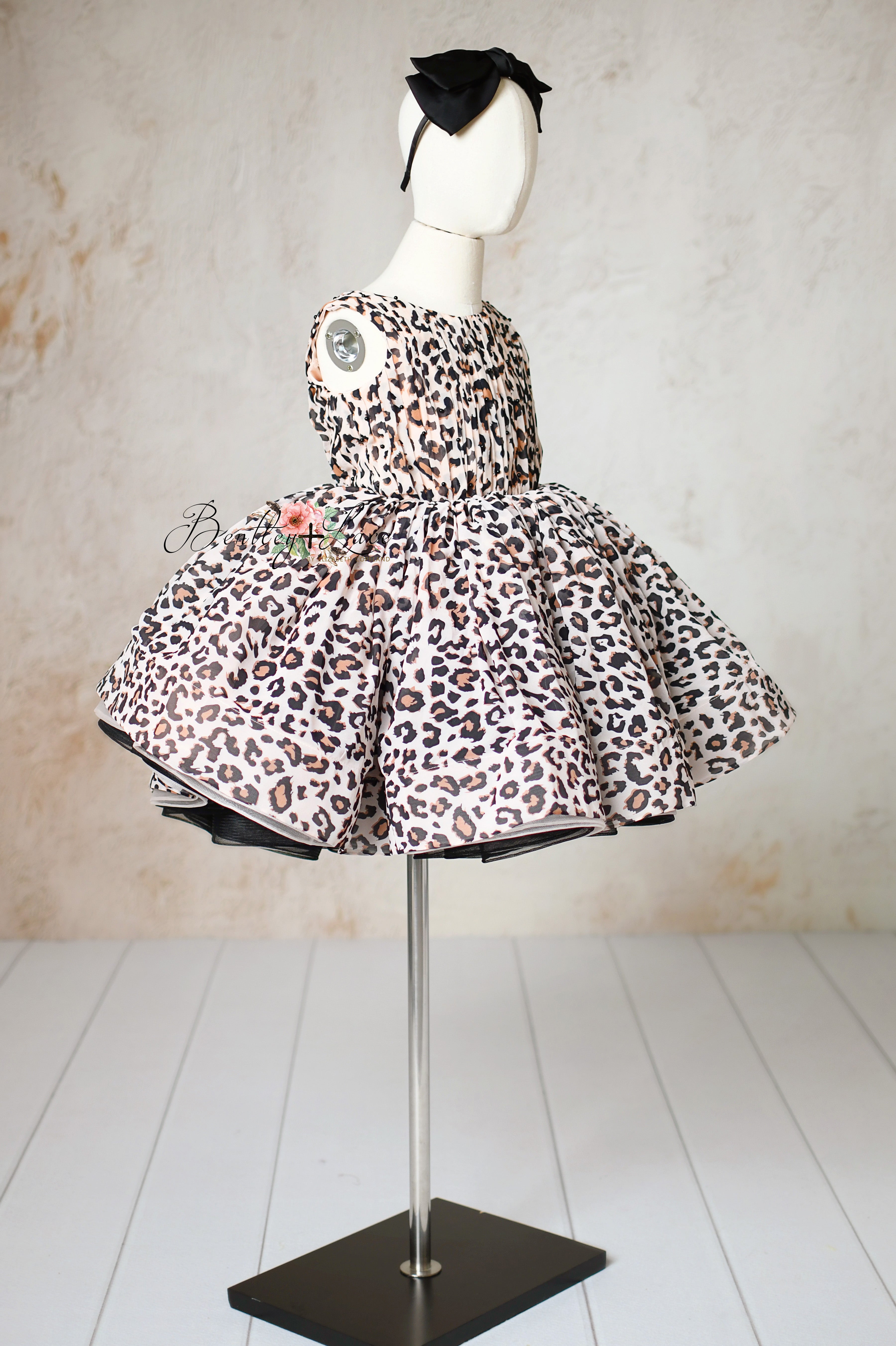 "Side view of a girls’ leopard dress with elegant puff sleeves for special occasions."