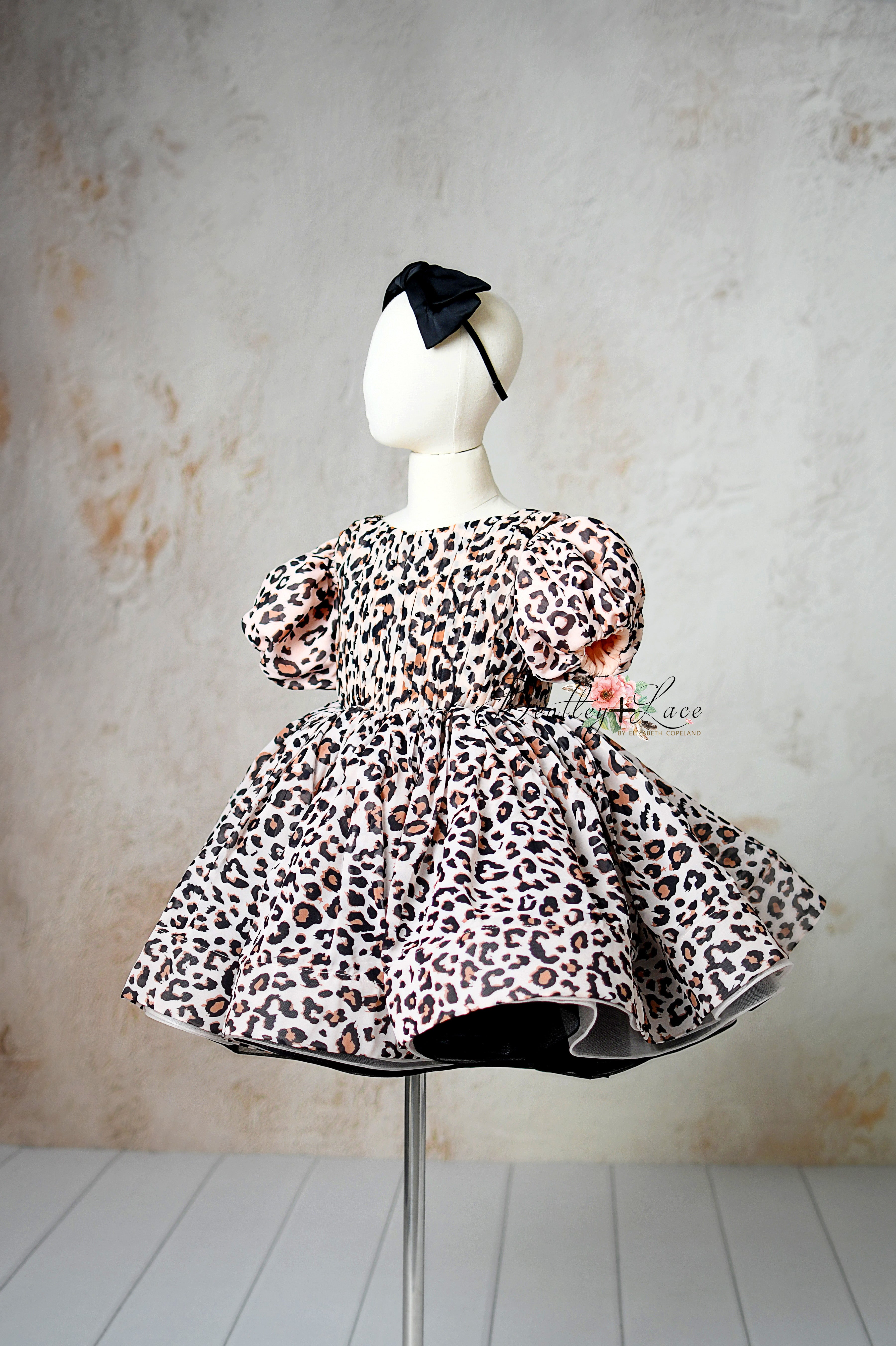 "Close-up of adjustable tie-back waist on a stylish leopard print girls’ dress."