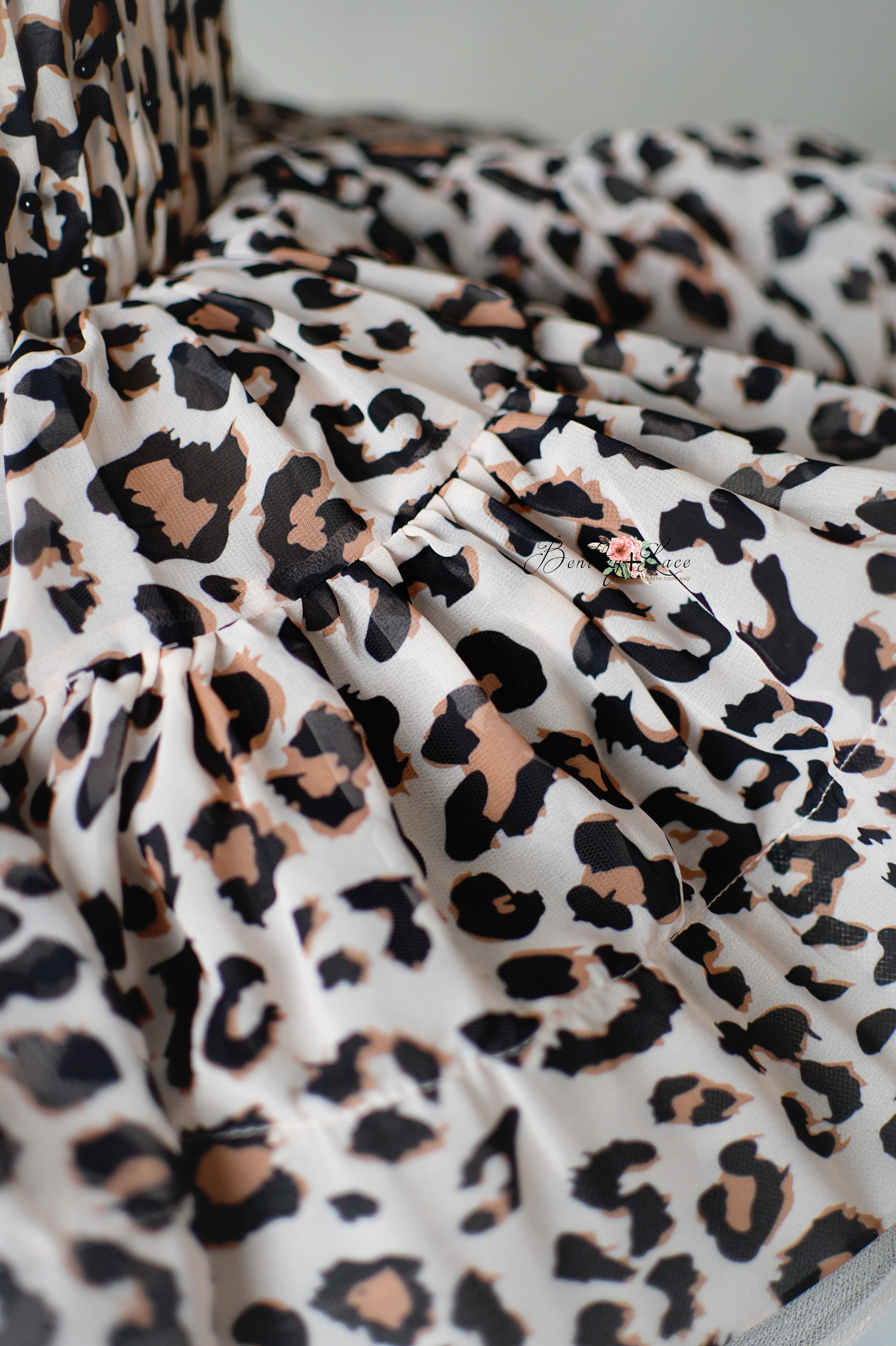 "Animal print toddler dress featuring puff sleeves and a layered petal-length skirt for photography sessions."