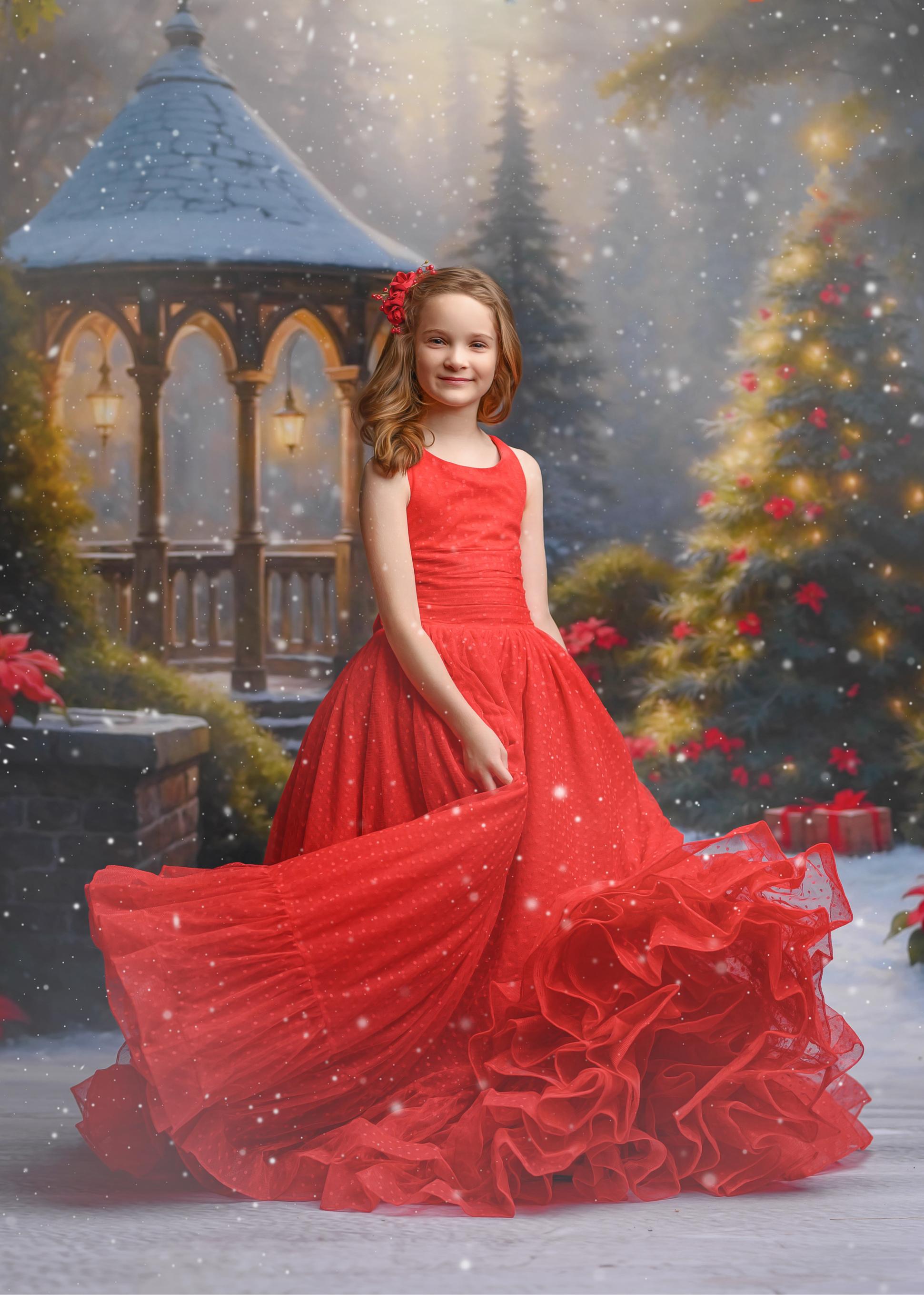 young girl wearing a red gown and twirling for holiday photography session