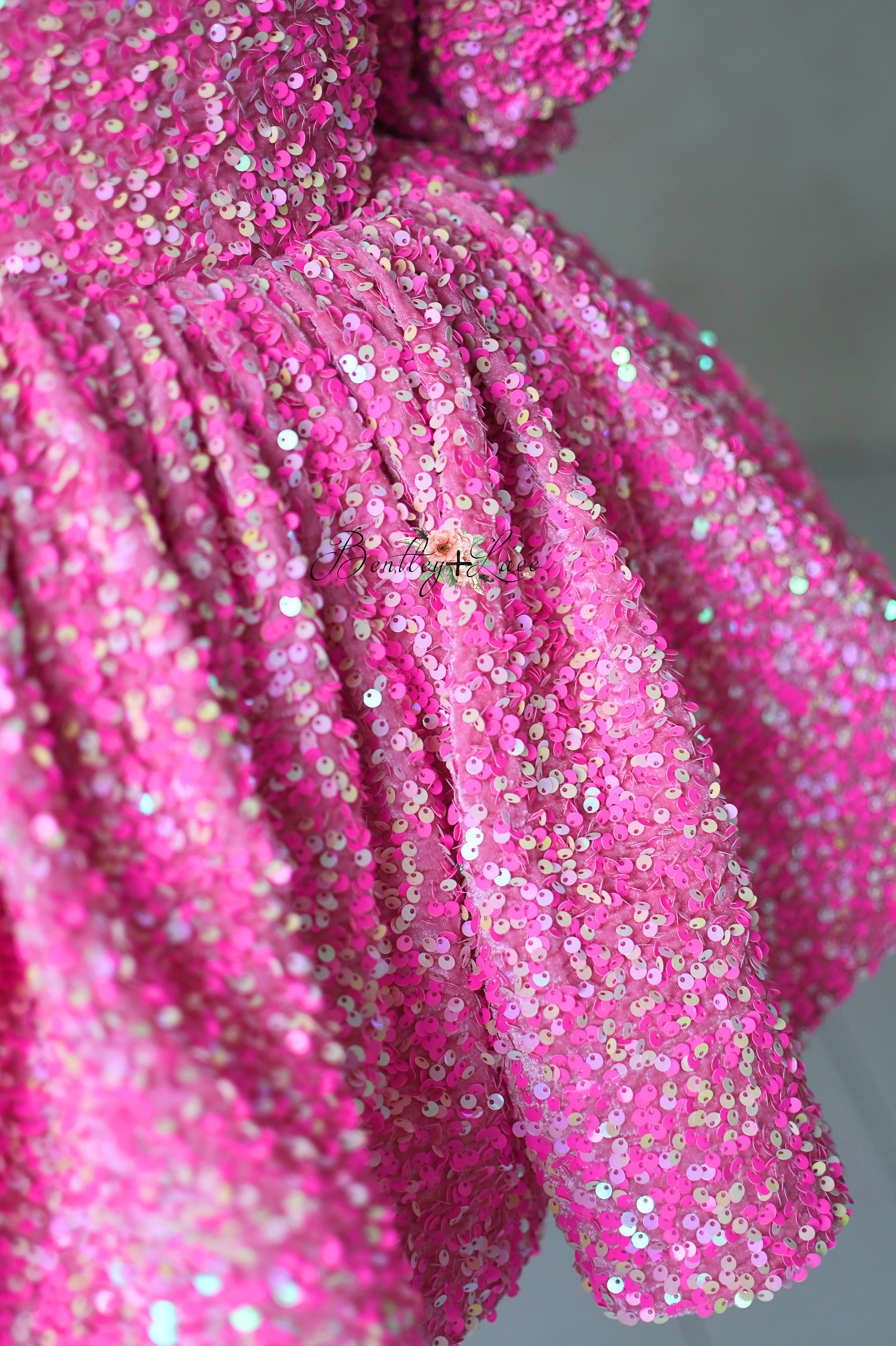 "Petal-length pink dress with shimmering sequins and optional puff sleeves for kids aged 6-7."