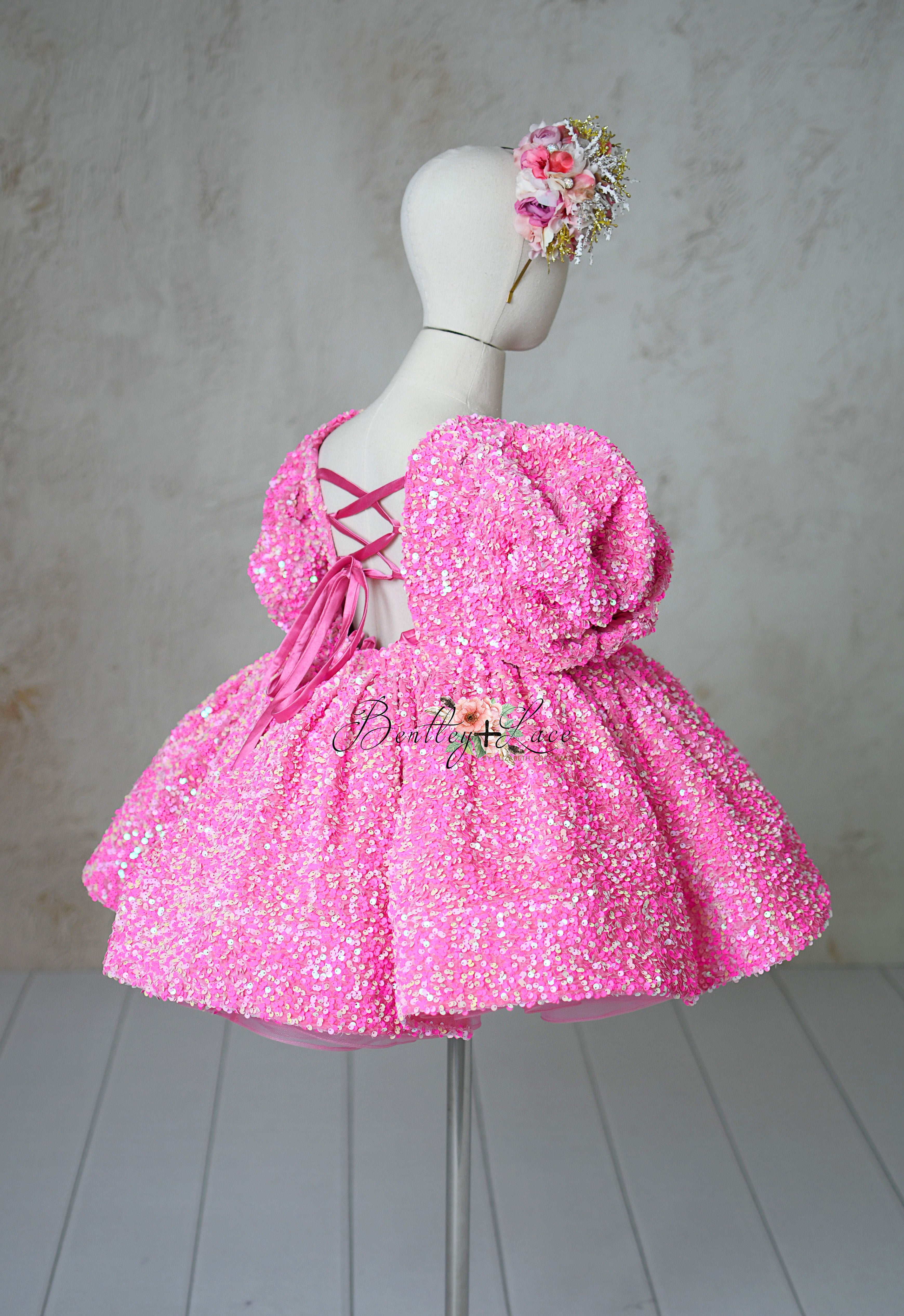"Detail shot of detachable puff sleeves and pink sequins on the Retro Candy dress for 6-7 year olds."