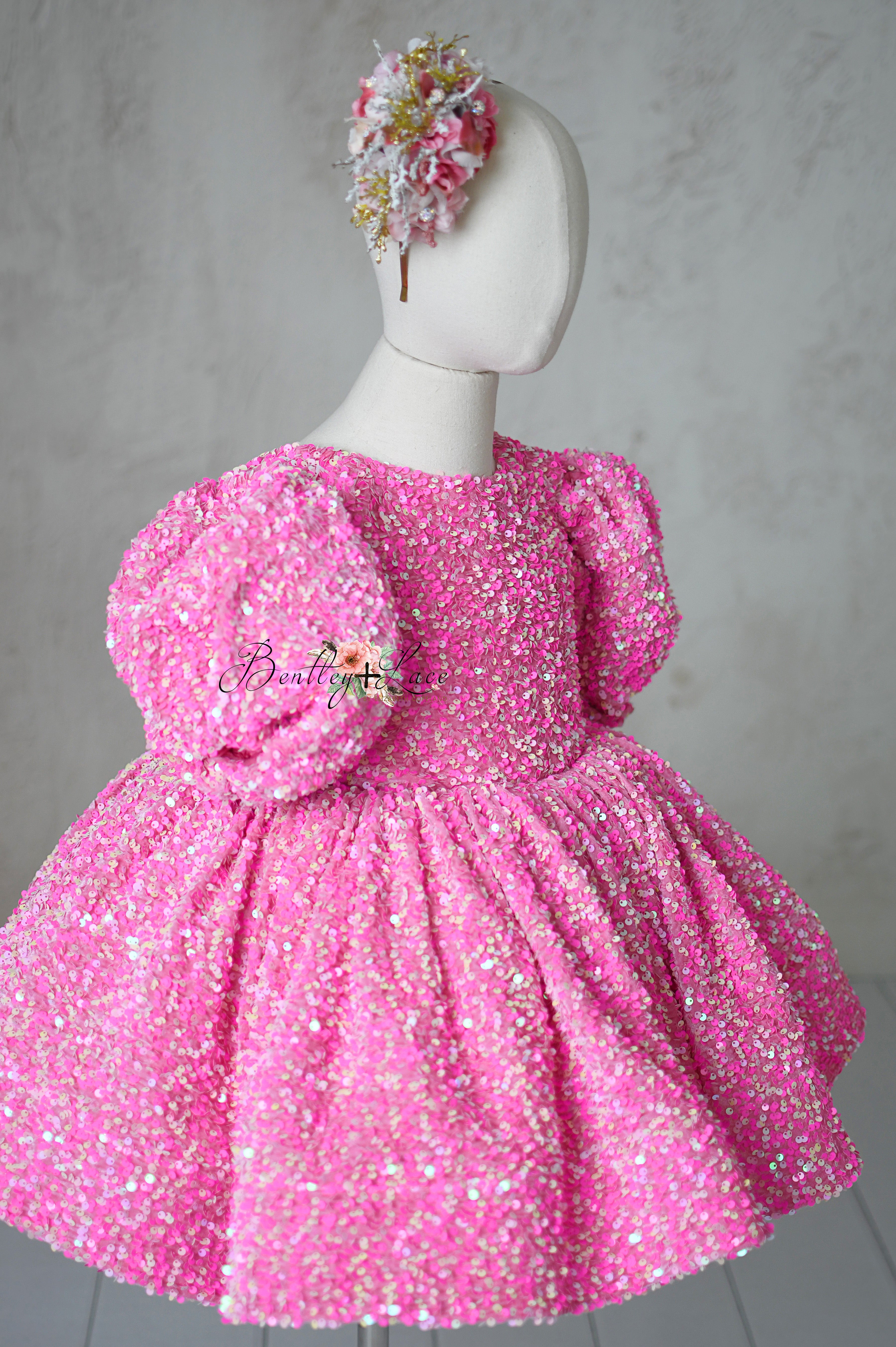 "Pink Candy Retro Dress with glittering sequins, removable sleeves, and petal-length skirt for kids aged 6-7."