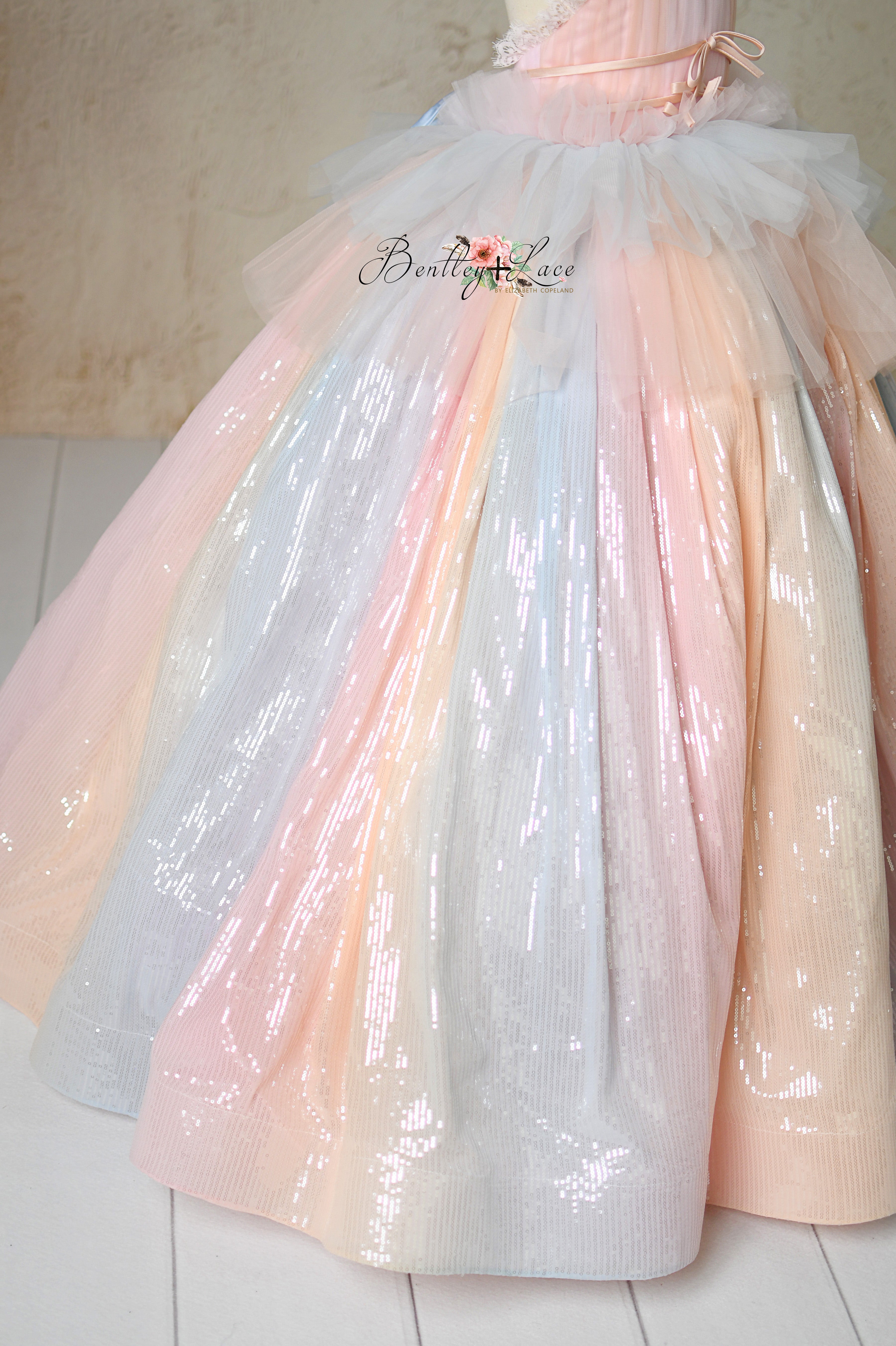 Ethereal gown with shimmering fabric, adjustable fit, and layered tulle.