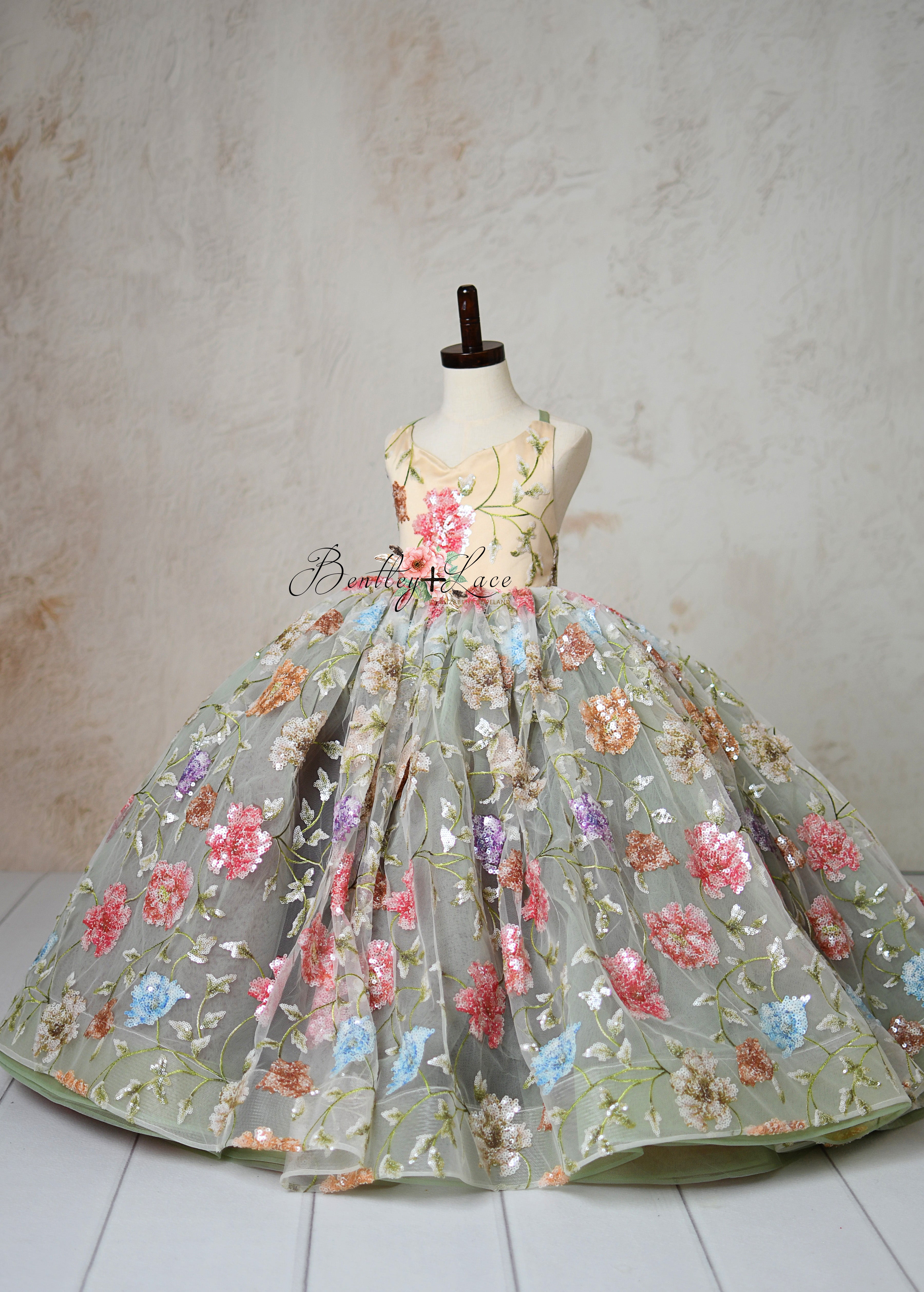 Elegant floral embroidered dress with pastel sequins on a mannequin.