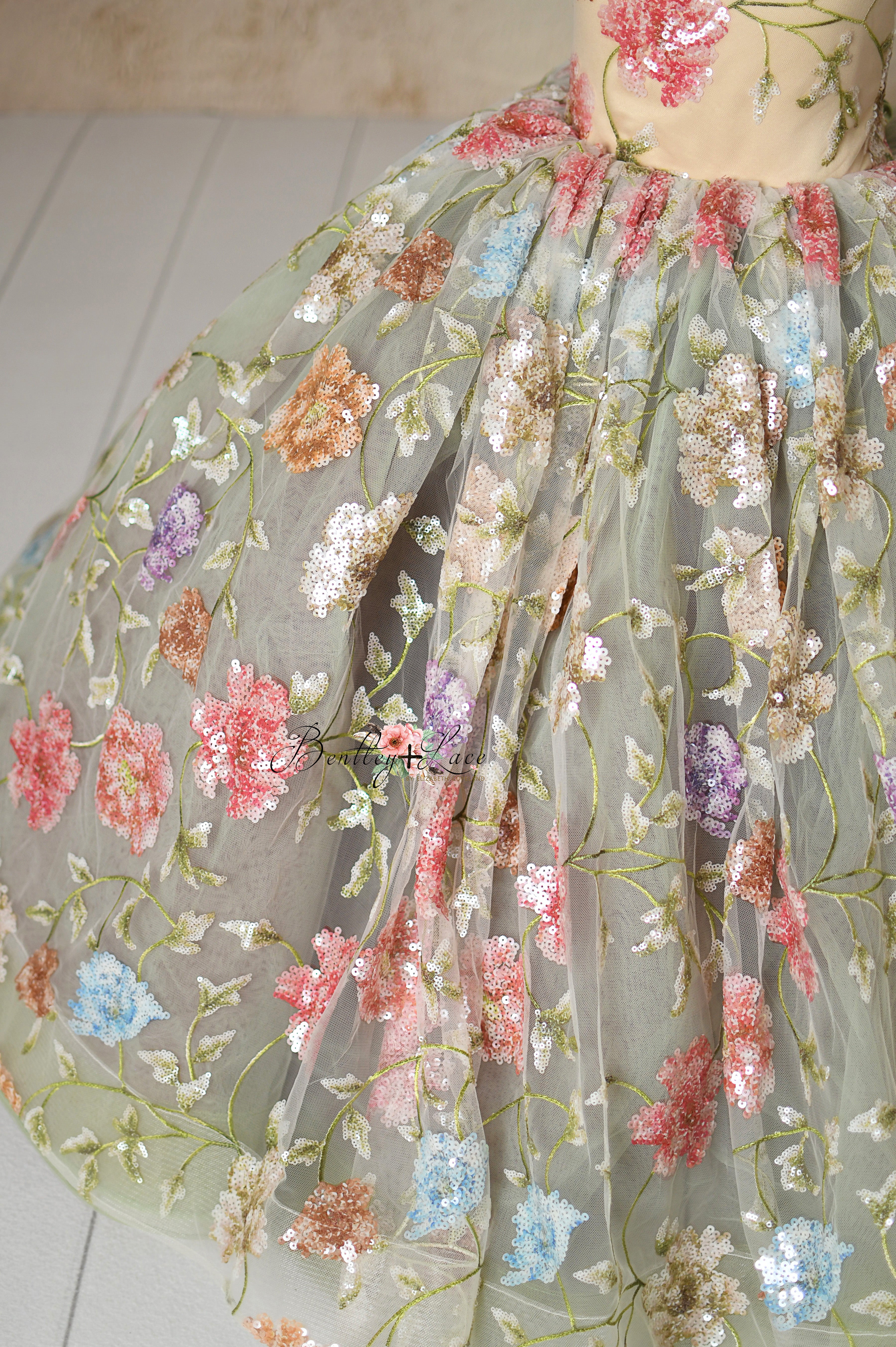 Close-up of a shimmering tulle gown with vibrant floral details.