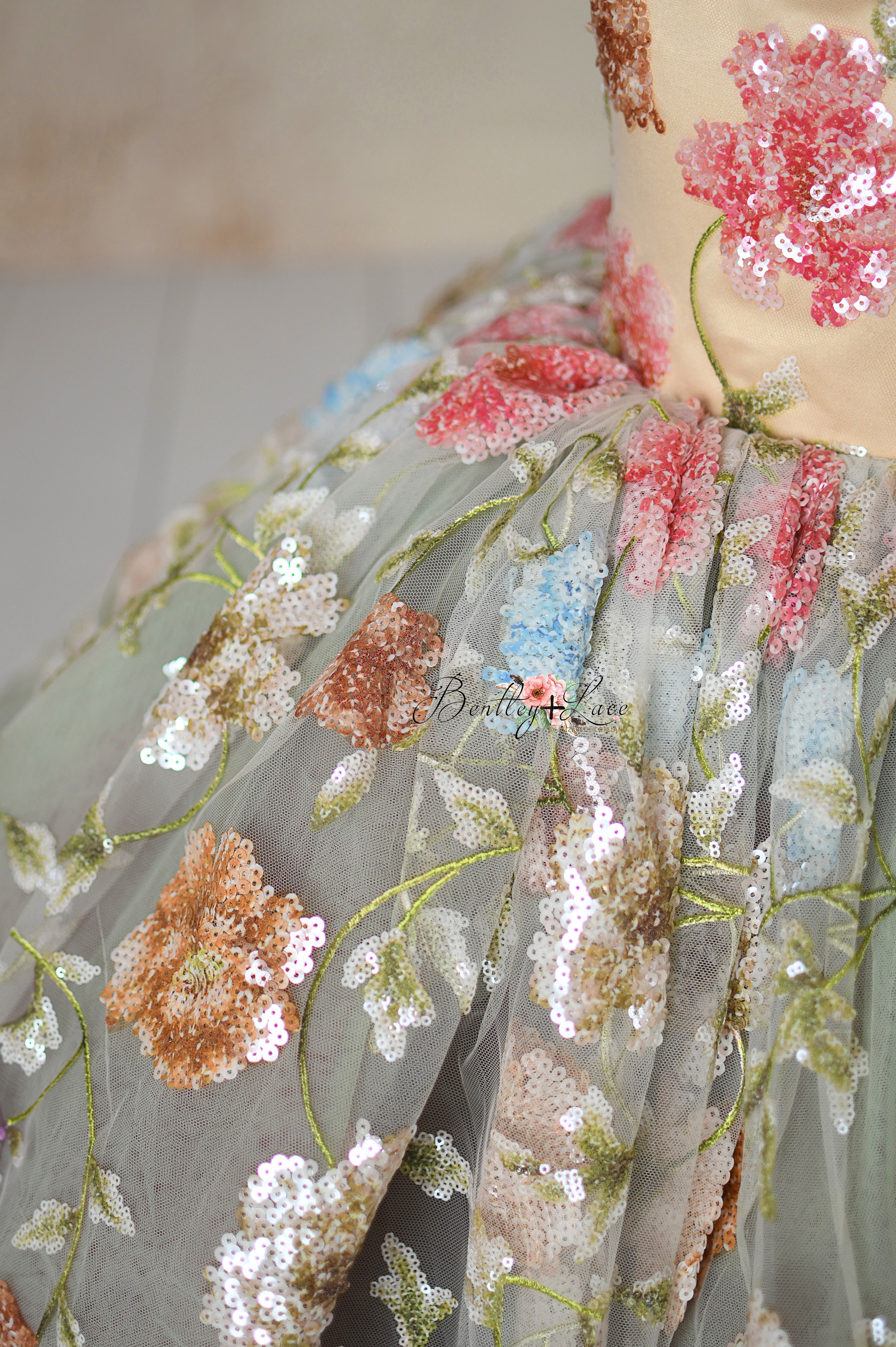 Designer dress with colorful embroidered flowers and soft tulle fabric.