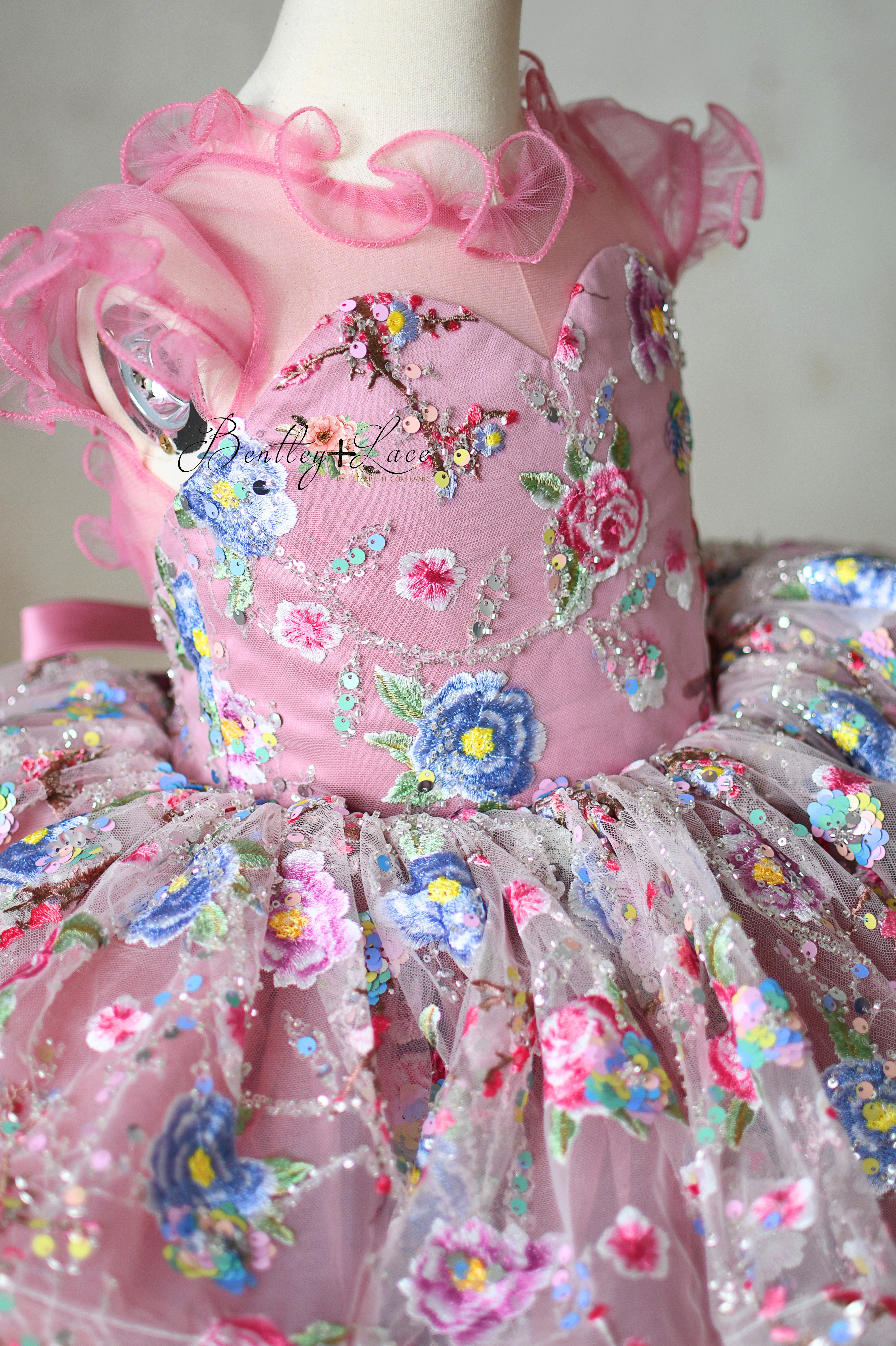 Soft blush pink bodice and tulle skirt with floral sequin details.