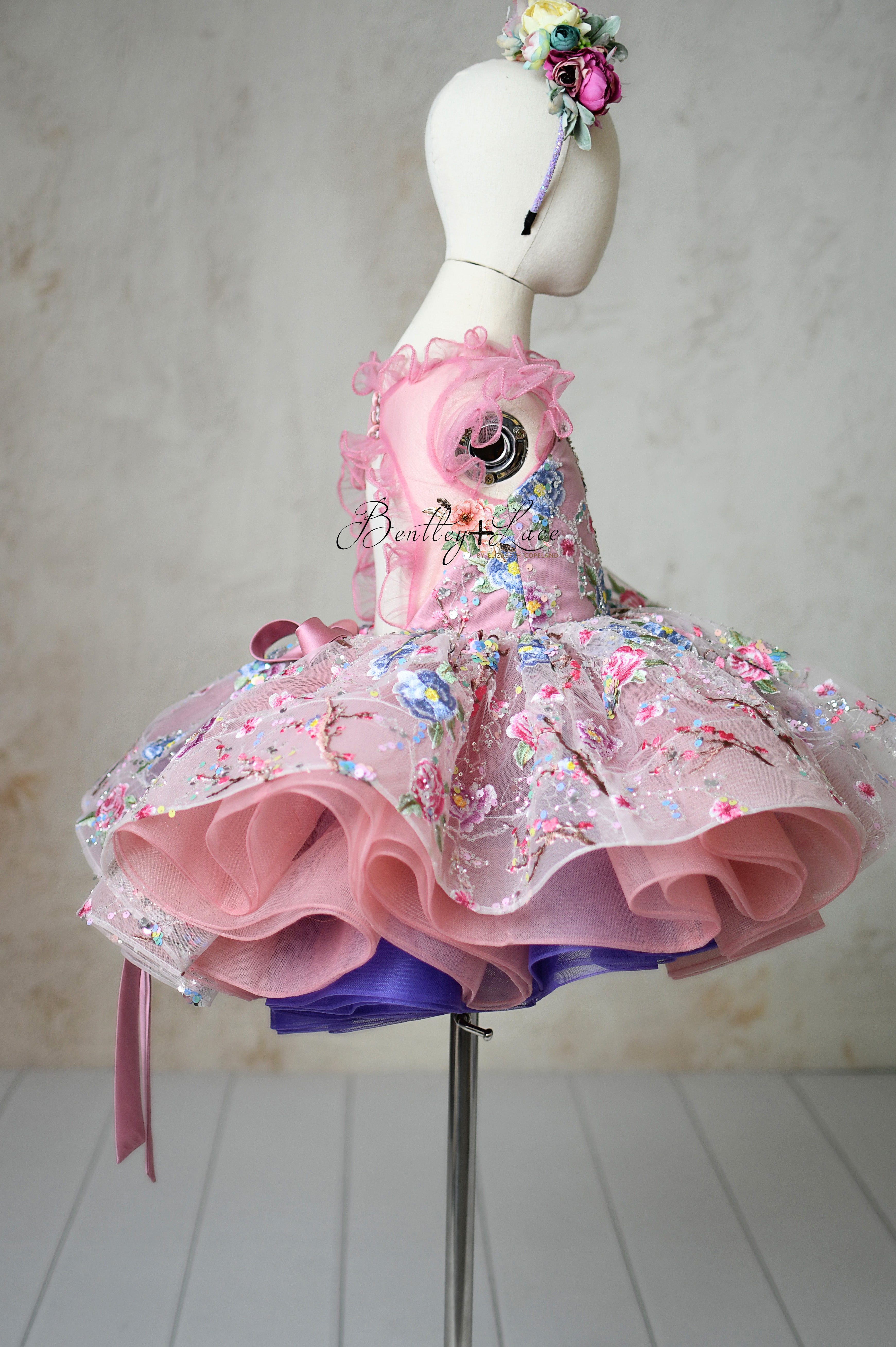Close-up of the ruffled tulle neckline and cap tulle sleeves of the "Blush & Blossom Melody" dress.