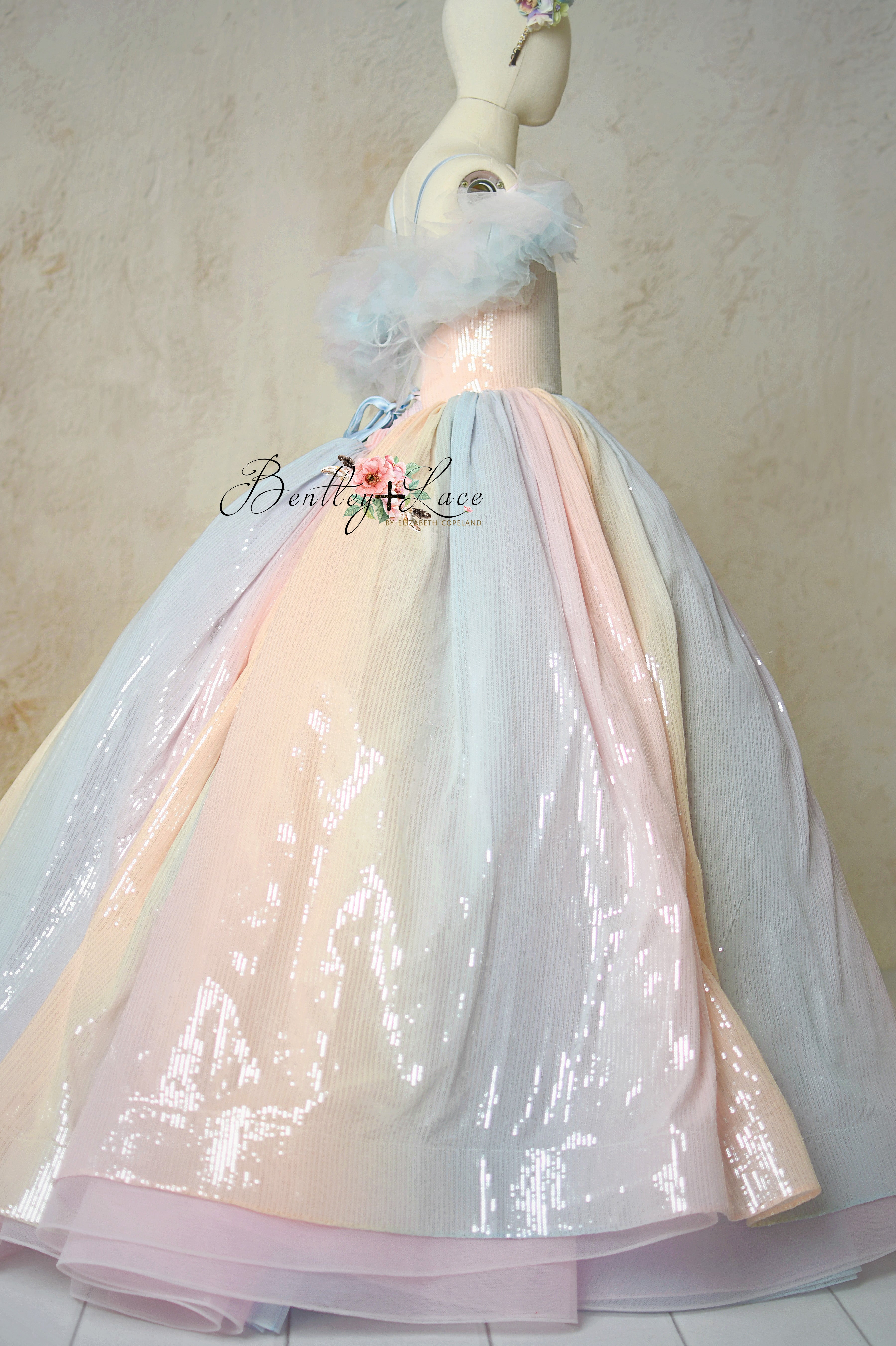 Aurora Gleam gown with shimmering pastel fabric and detachable sleeves in a photoshoot setting.