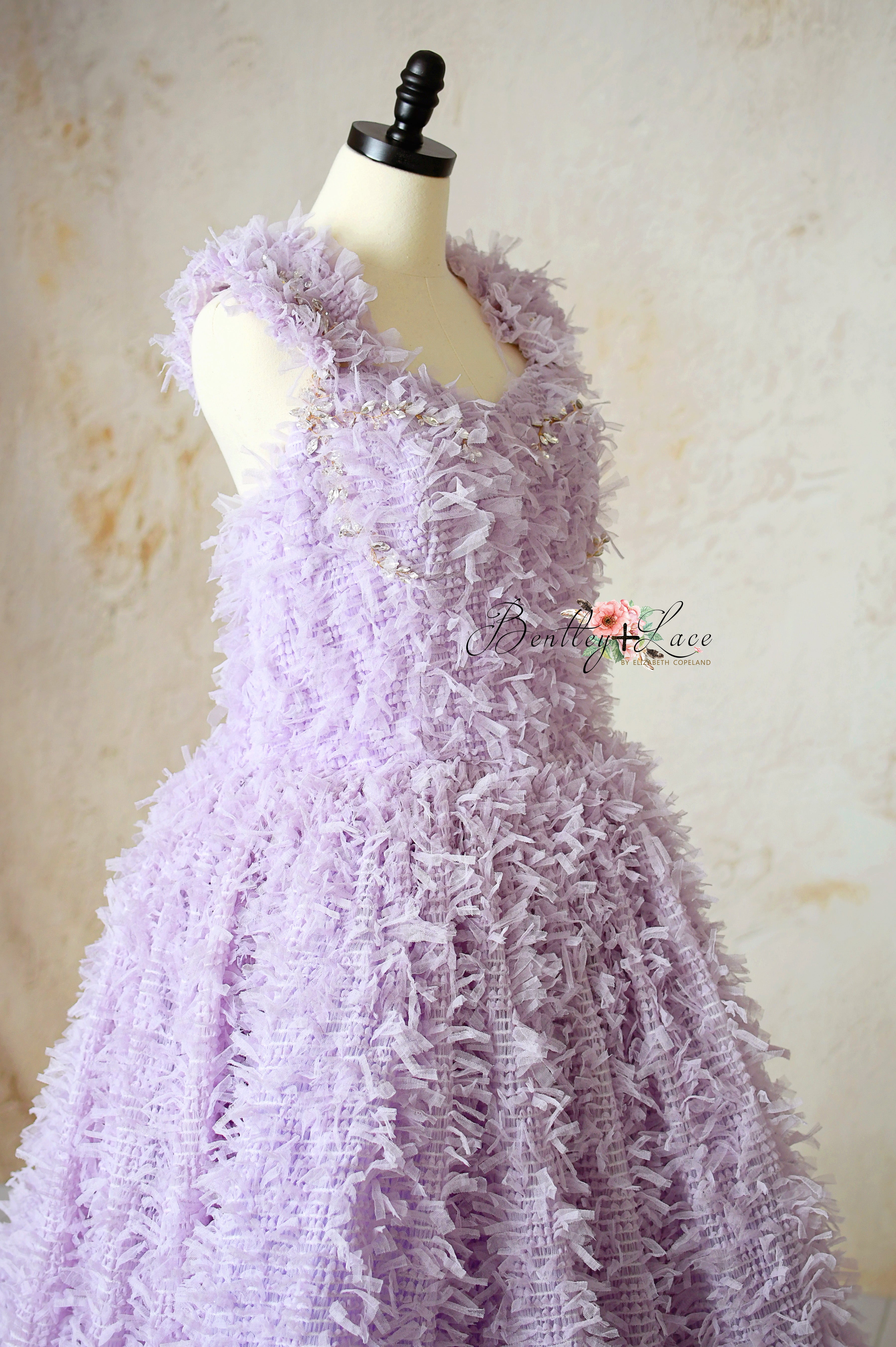 Close-up of rhinestone hand-sewn details on lavender couture gown neckline.