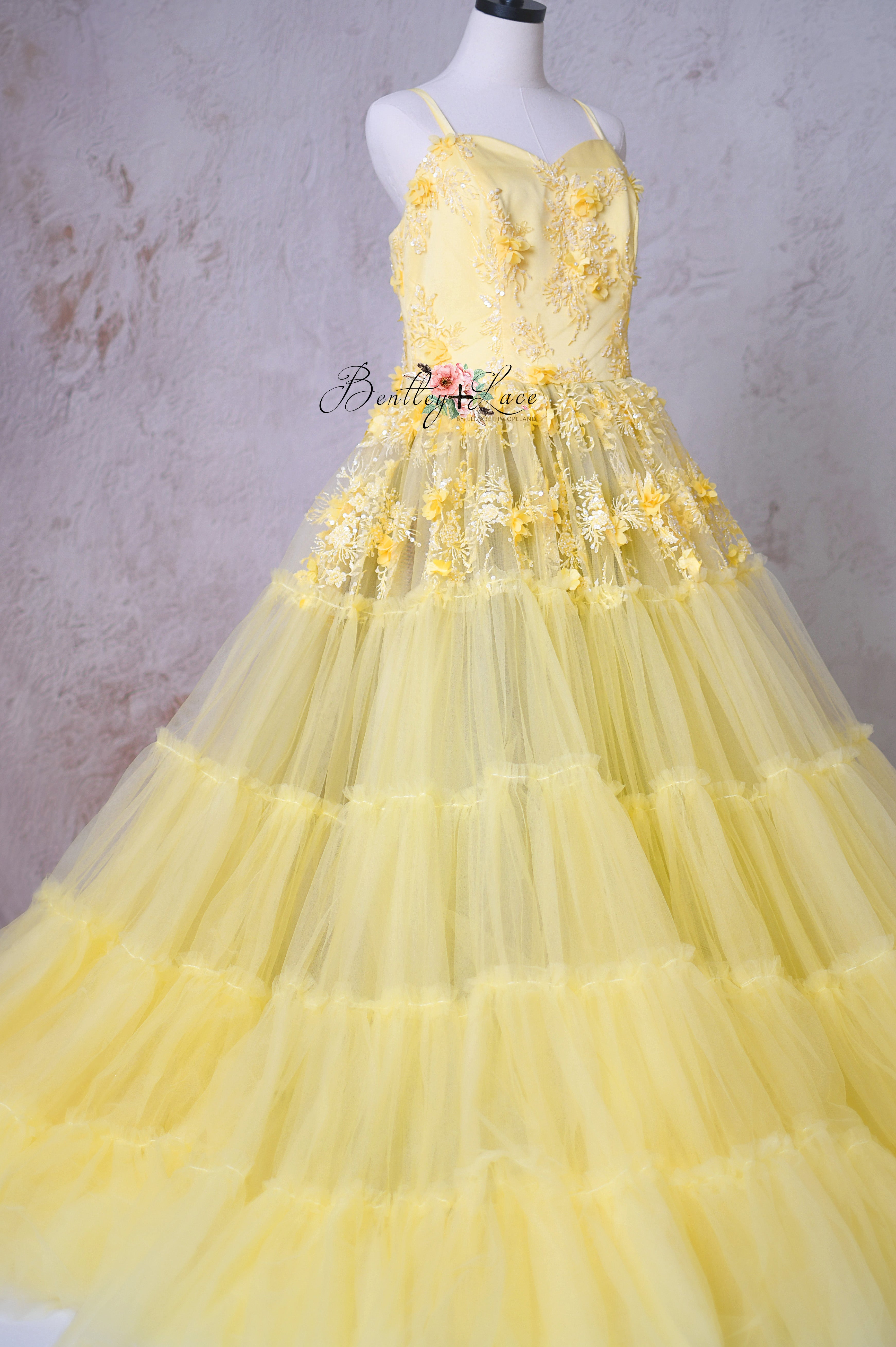 Soft ruffled layers of the skirt, adding dimension and movement to the gown.