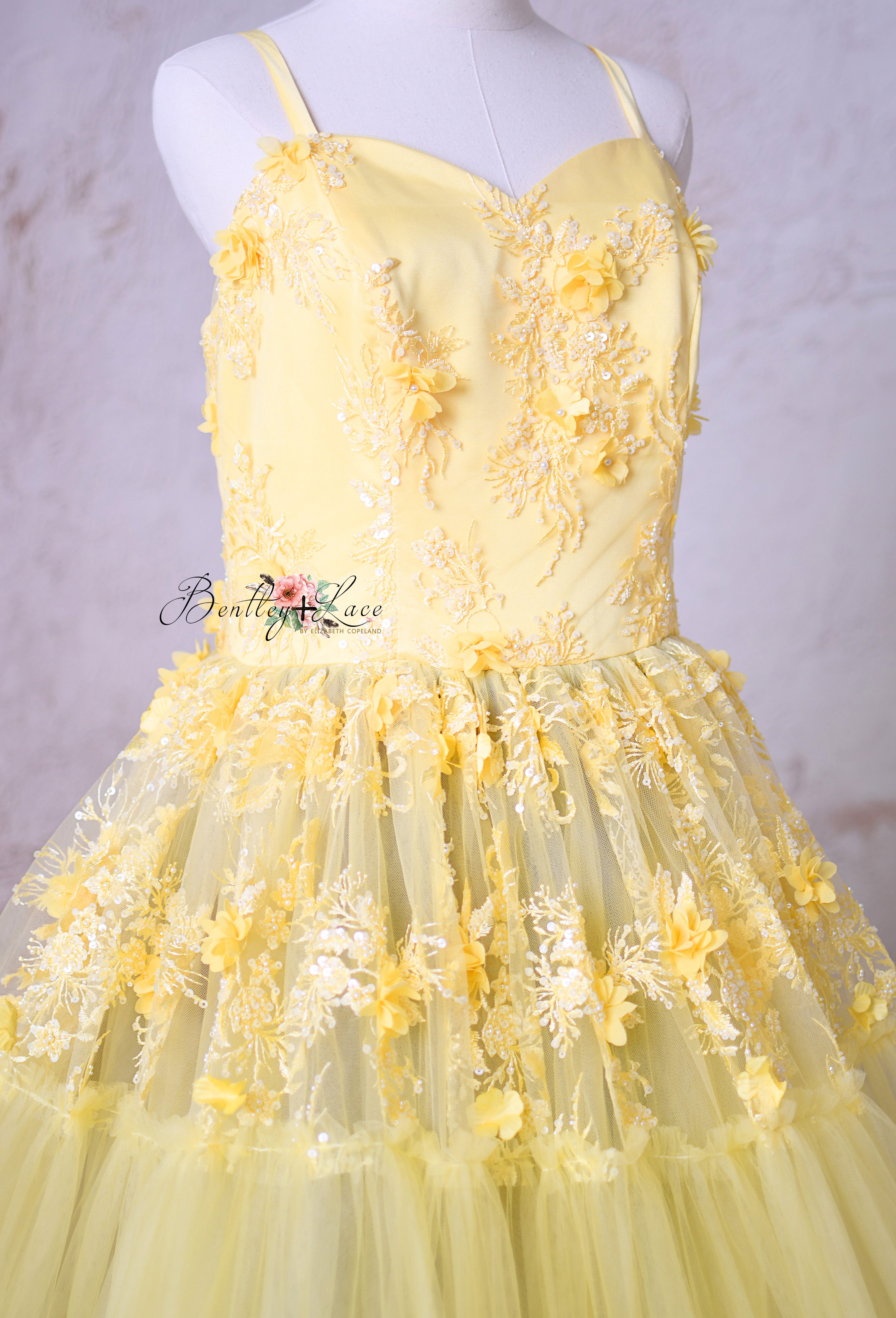 "Detailed shot of the 3D floral appliqués and blush pink accents on the Buttercup gown."