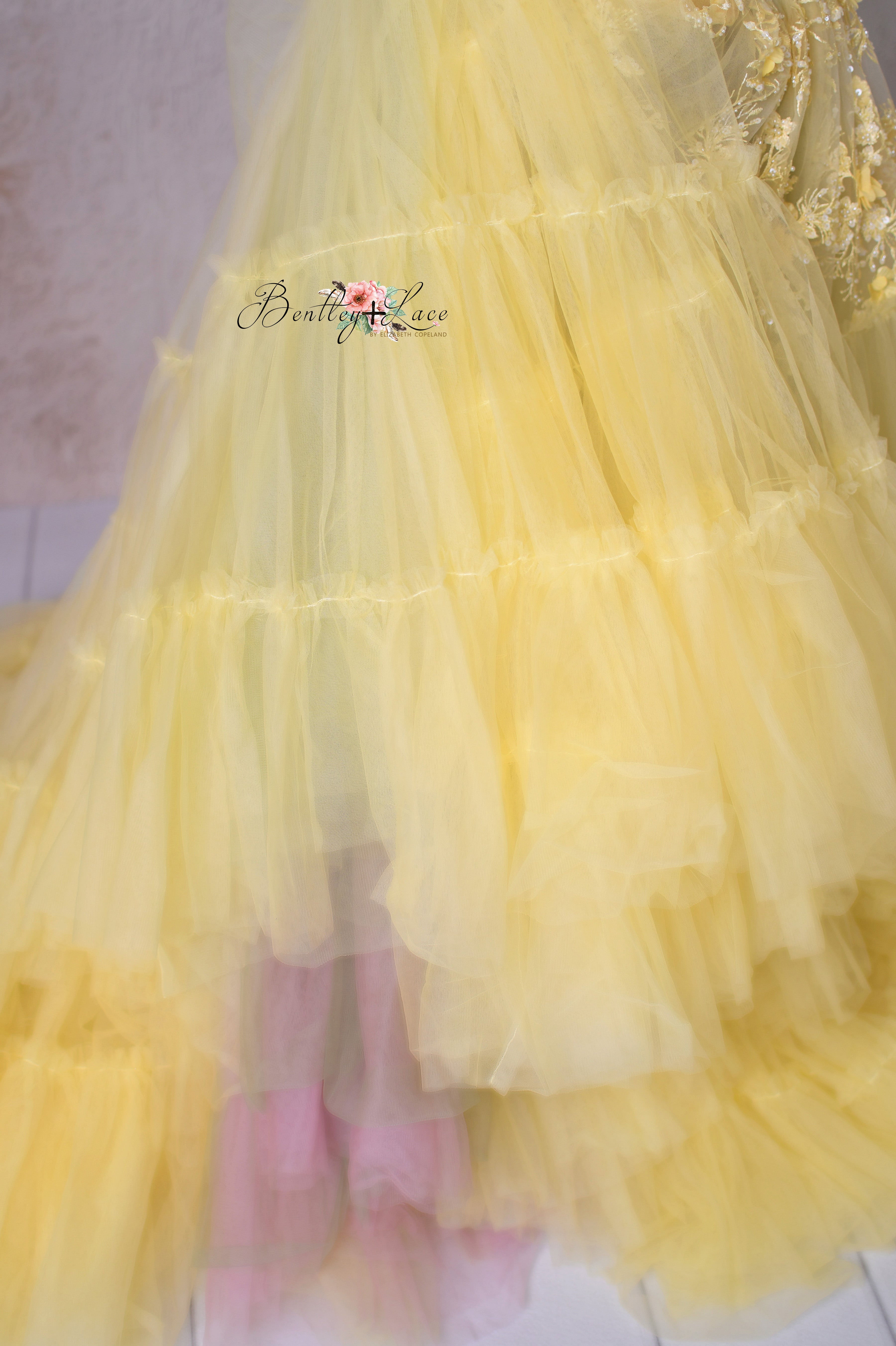 A dreamy close-up of the gown’s tulle layers, showcasing texture and subtle color contrasts.