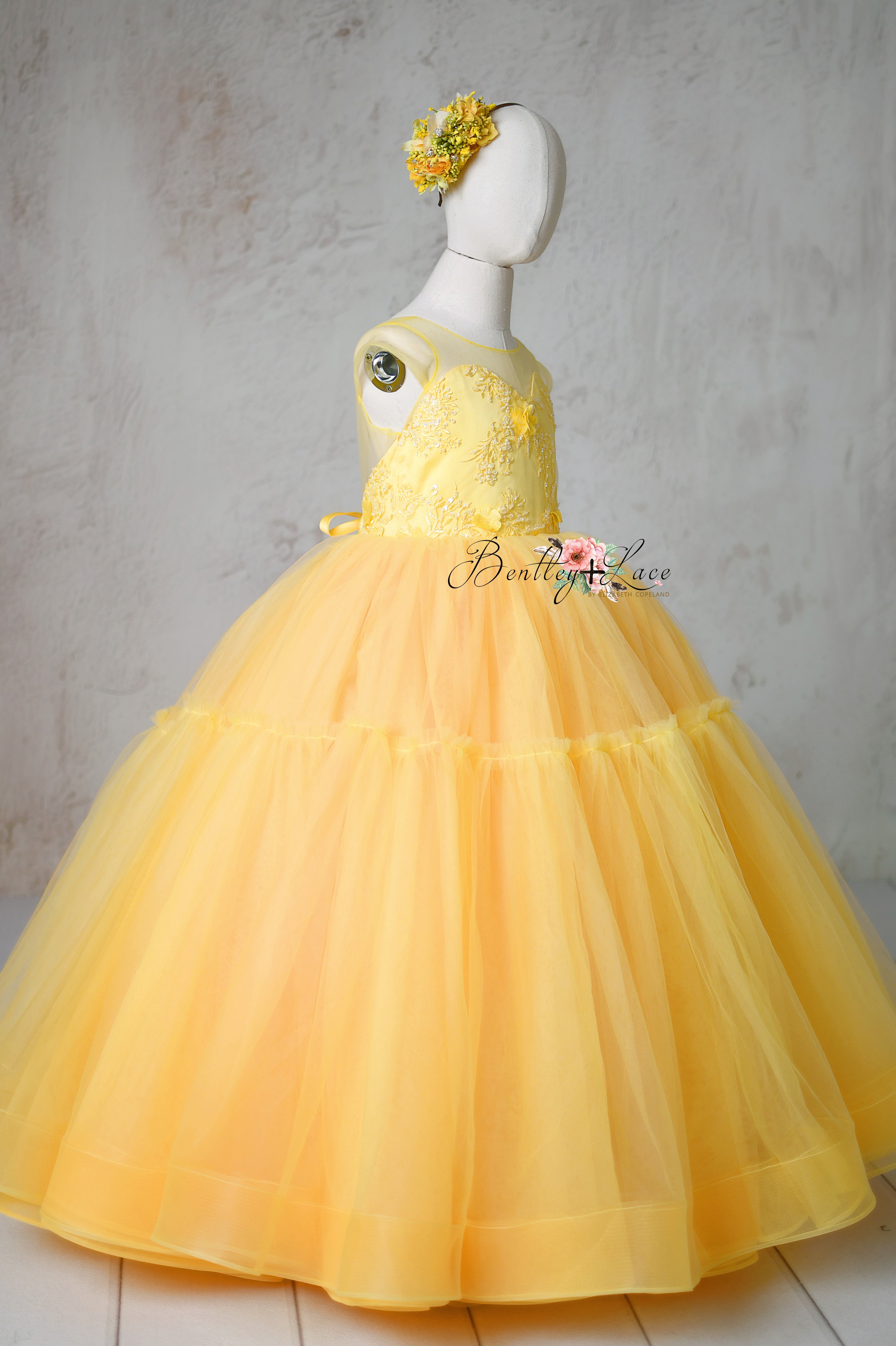 A vibrant sunshine-yellow Buttercup gown with delicate 3D floral appliqués on the bodice.