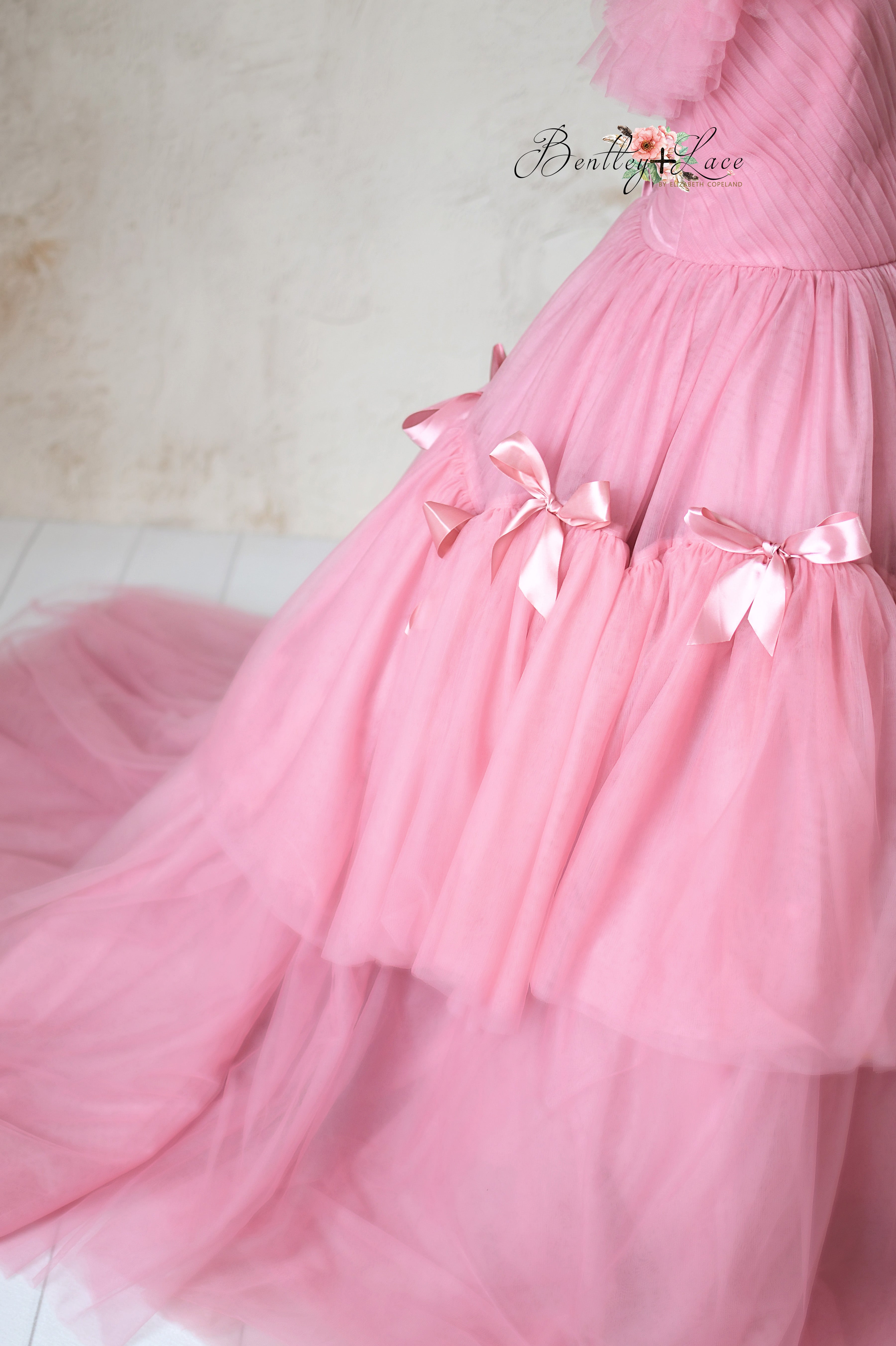 High-fashion pink gown with intricate design details and an ethereal silhouette.