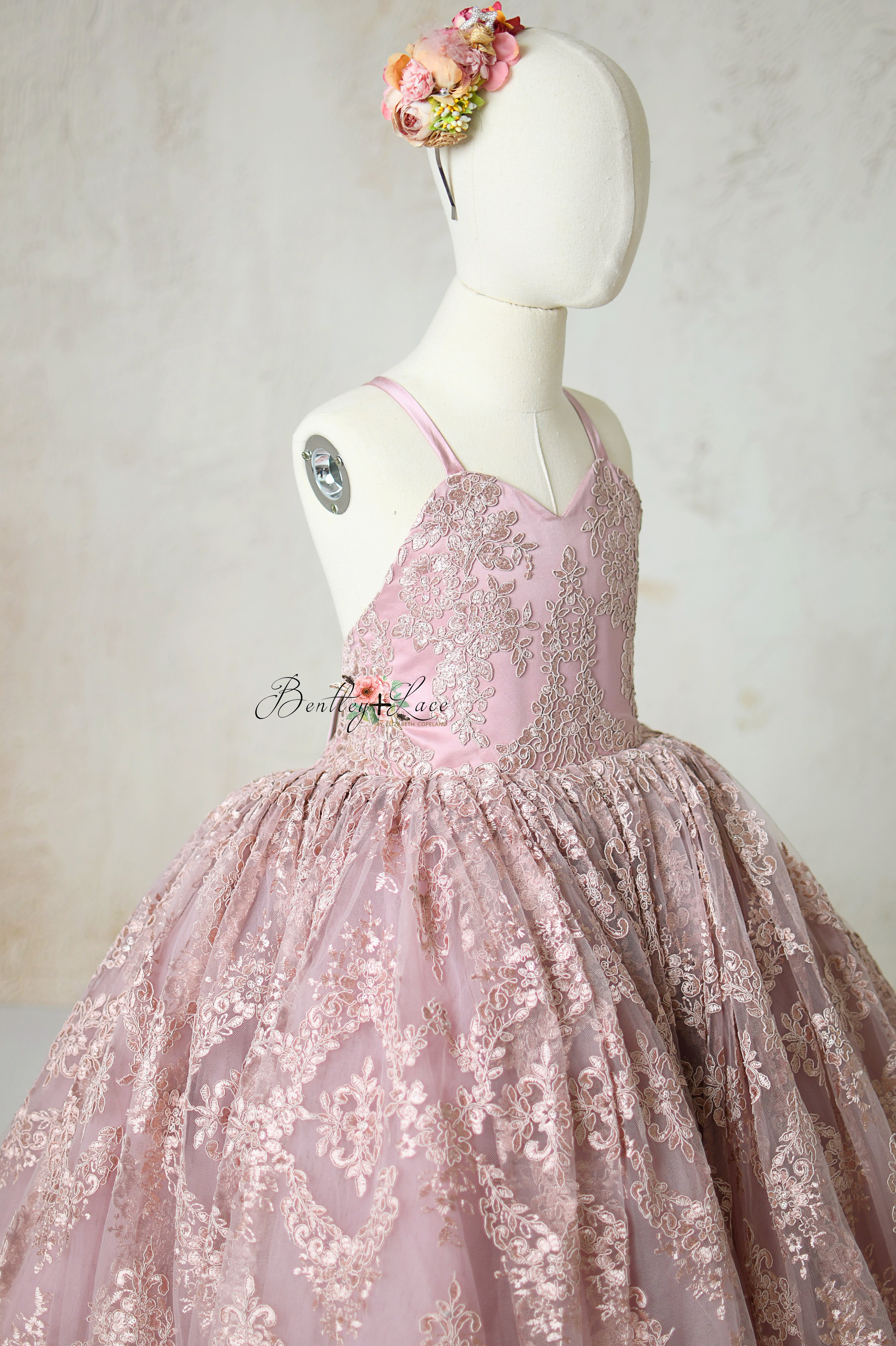 Vintage-inspired mauve gown with a floral waist accent and delicate, scalloped lace edges.