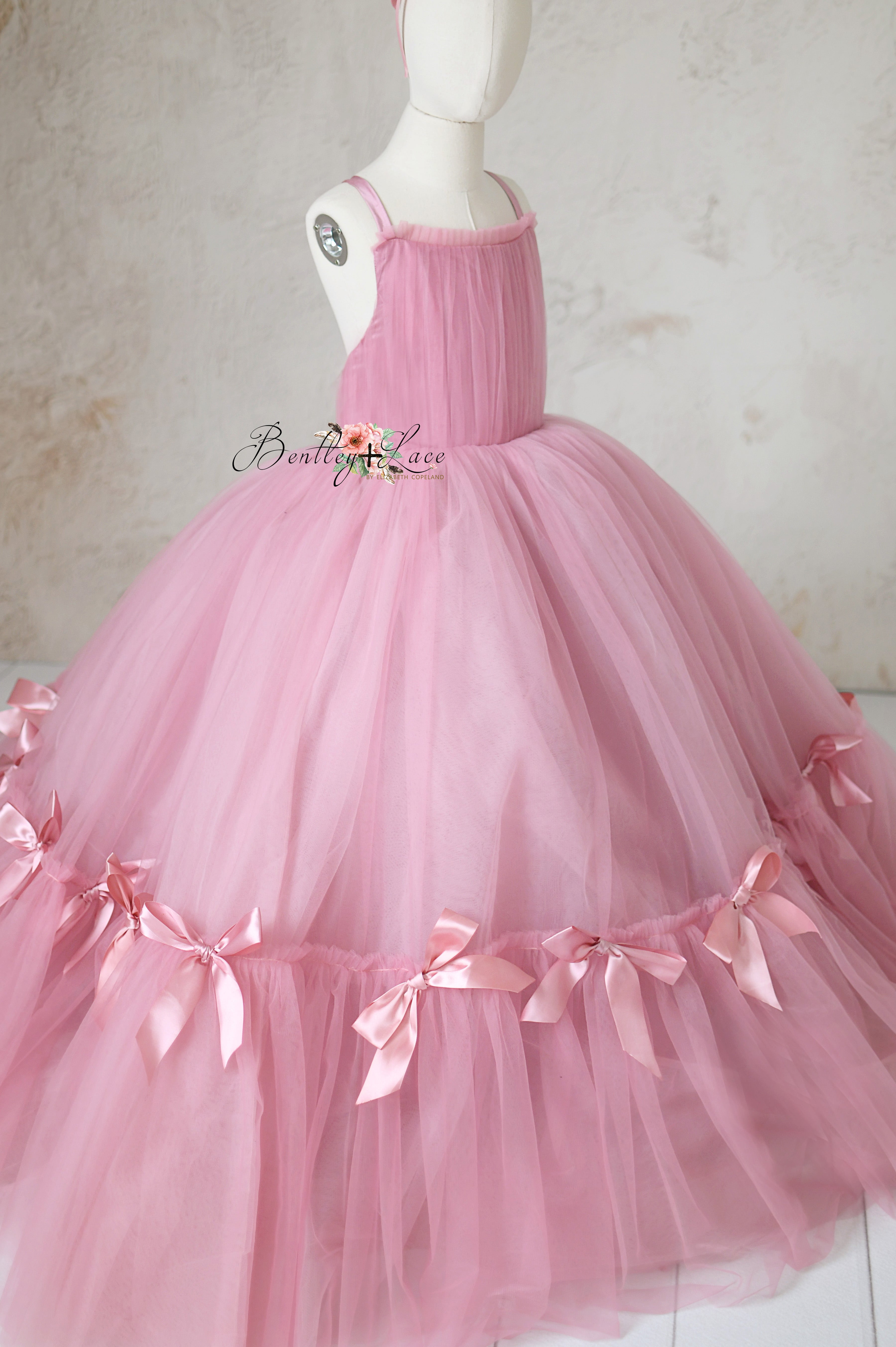 Detailed shot of the hand-sewn bows on the Bows of Grace gown's skirt, showcasing impeccable craftsmanship.