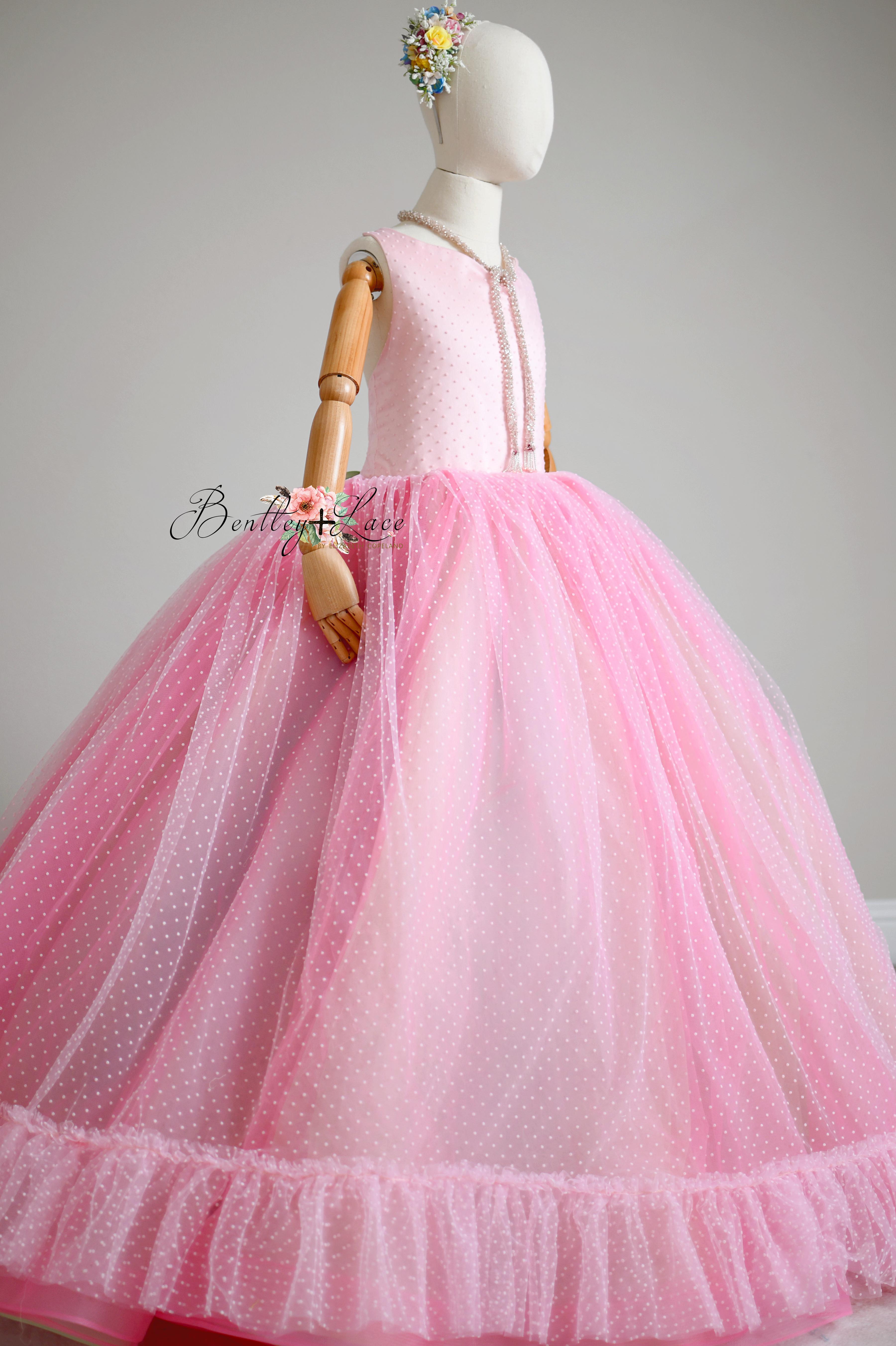"Swish Dot Couture Pastel gown styled in a photoshoot, showcasing its flawless design with layers of pastel tulle and Swiss dot fabric."