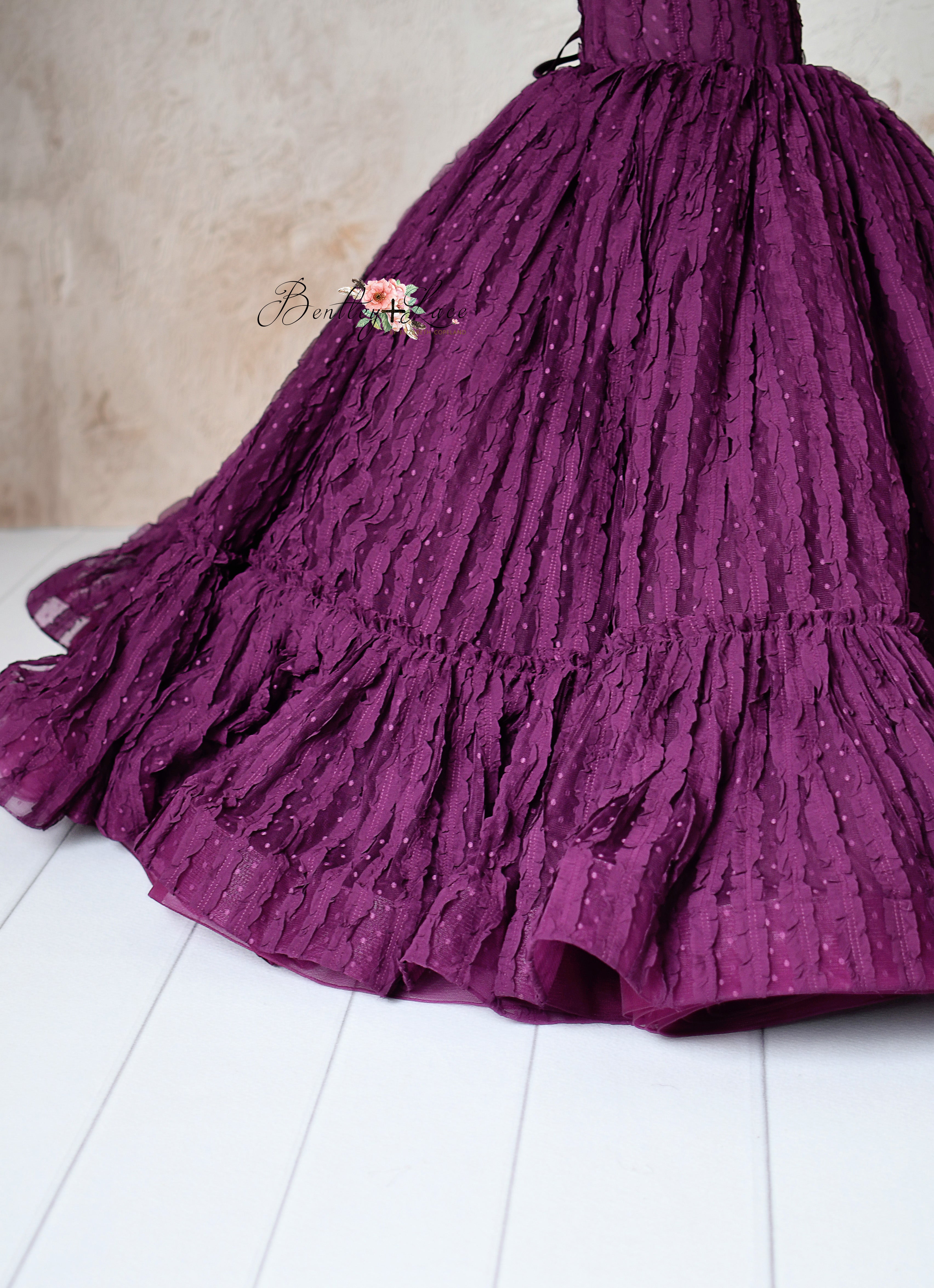 Elegant plum-colored gown with delicate ruffled lace details, designed for special occasions.