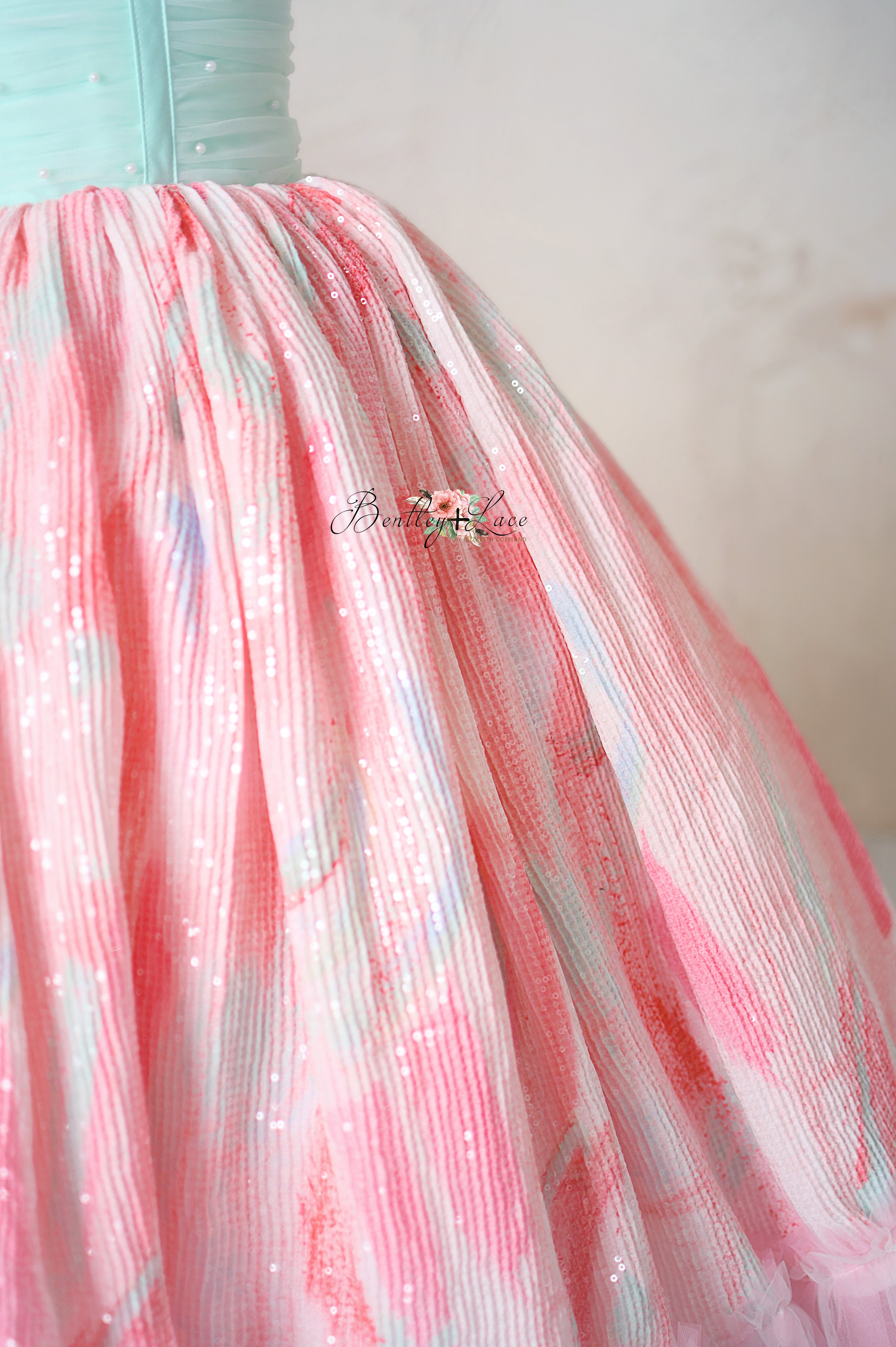 "Side view of the Cotton Candy Dream gown featuring a pearl-adorned mint bodice and flowing pink tulle skirt."