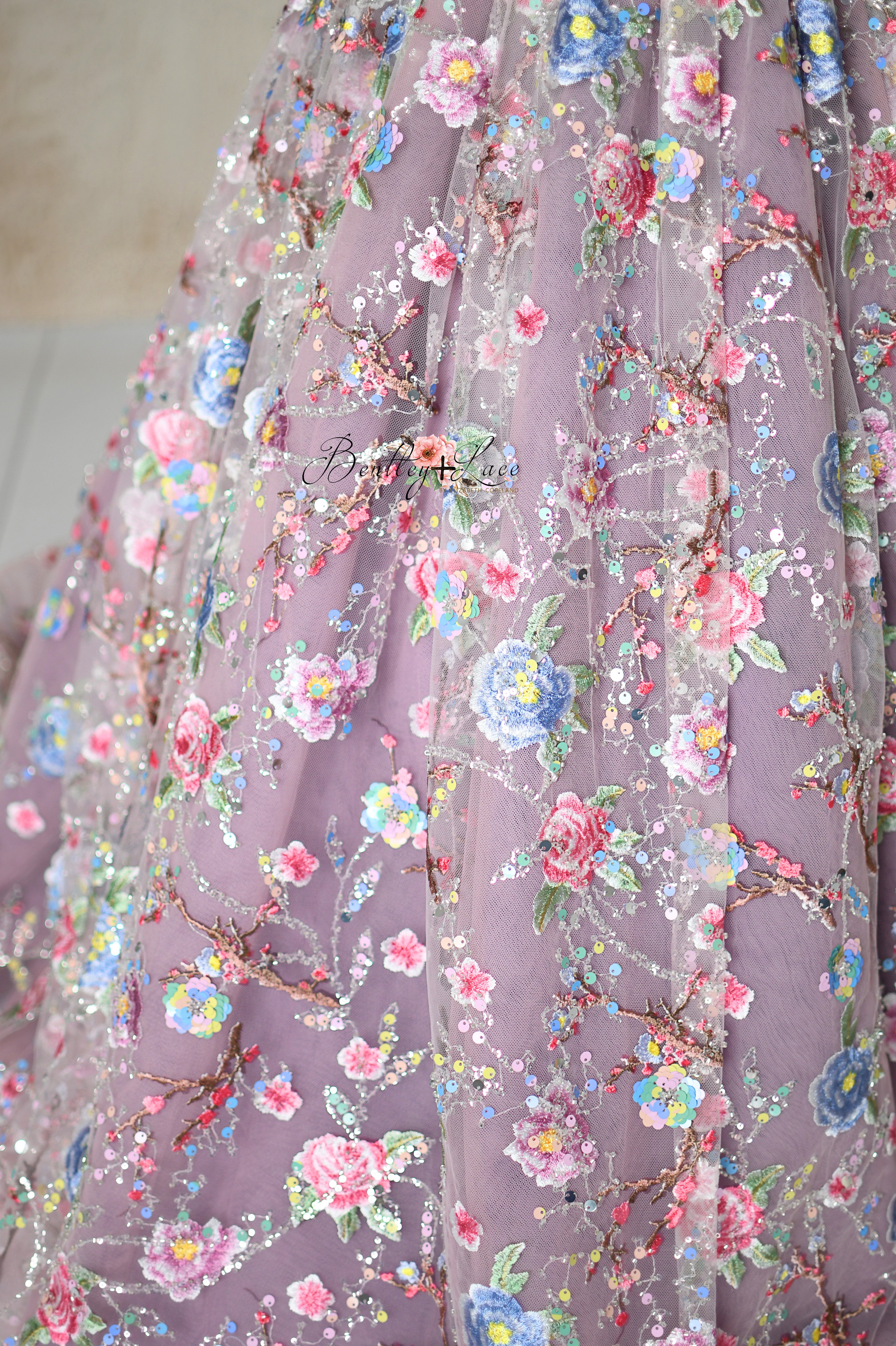 Close-Up of Embroidered Floral Details on Pink Tulle Fabric
