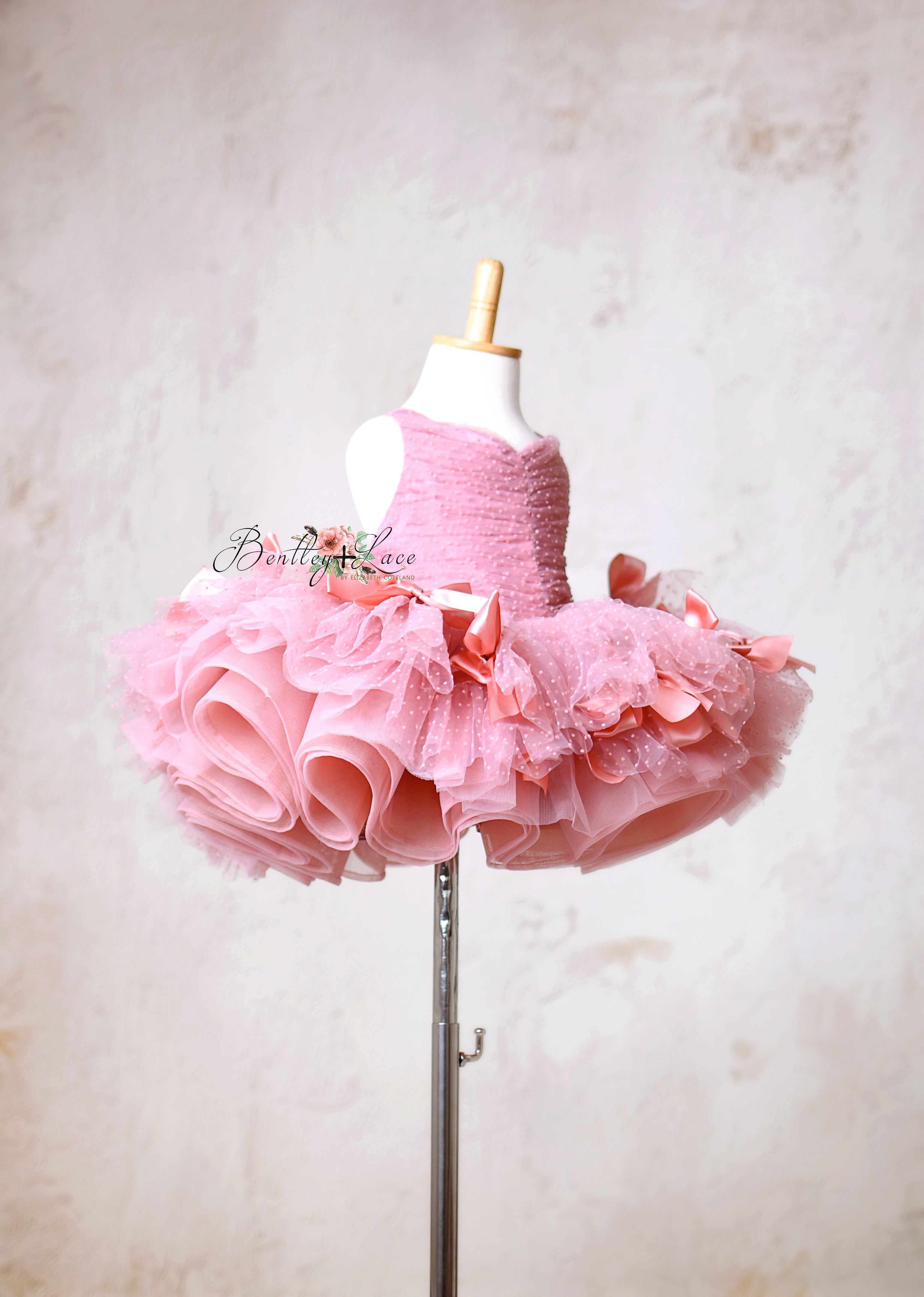 Elegant pink tutu dress with delicate polka dot tulle and satin bows.